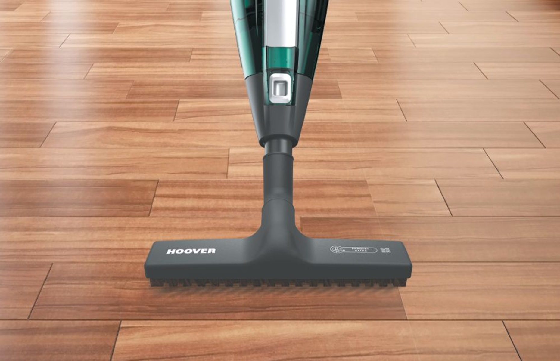 Primo piano della testina dell'aspirapolvere su pavimento in legno, con logo Hoover.