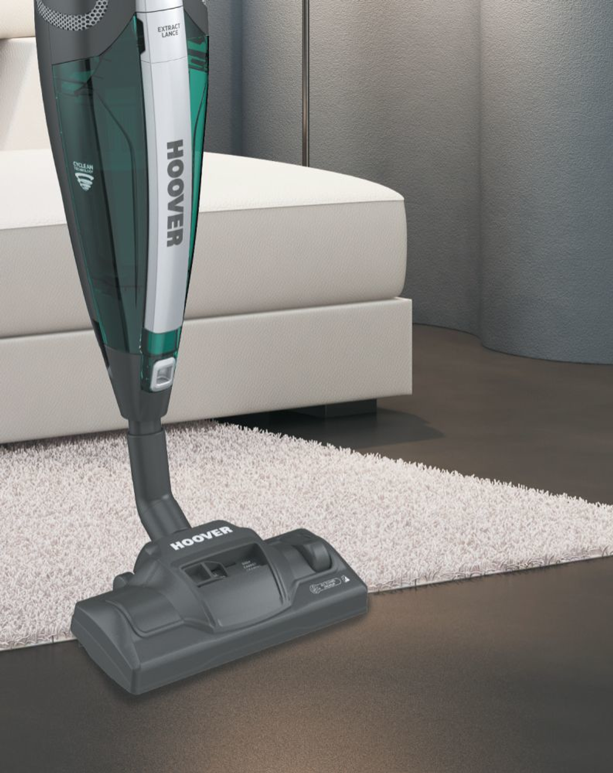 Un aspirapolvere verde e argento. L'aspirapolvere è verticale e su un tappeto.