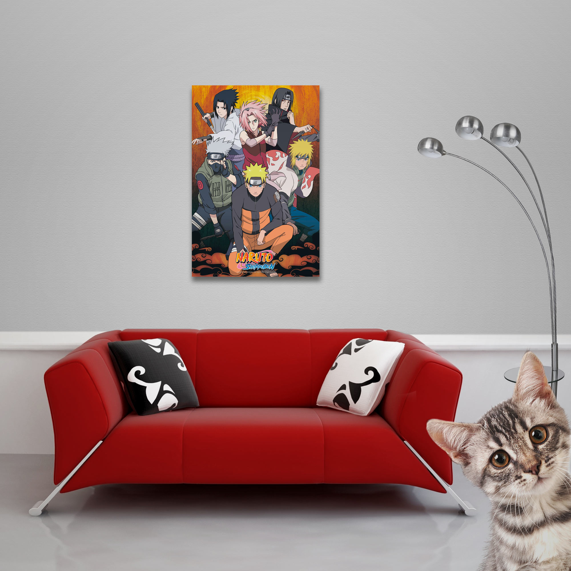 Ein rotes Sofa mit Kissen und einem Poster von Anime-Charakteren. Eine Katze lugt von rechts.