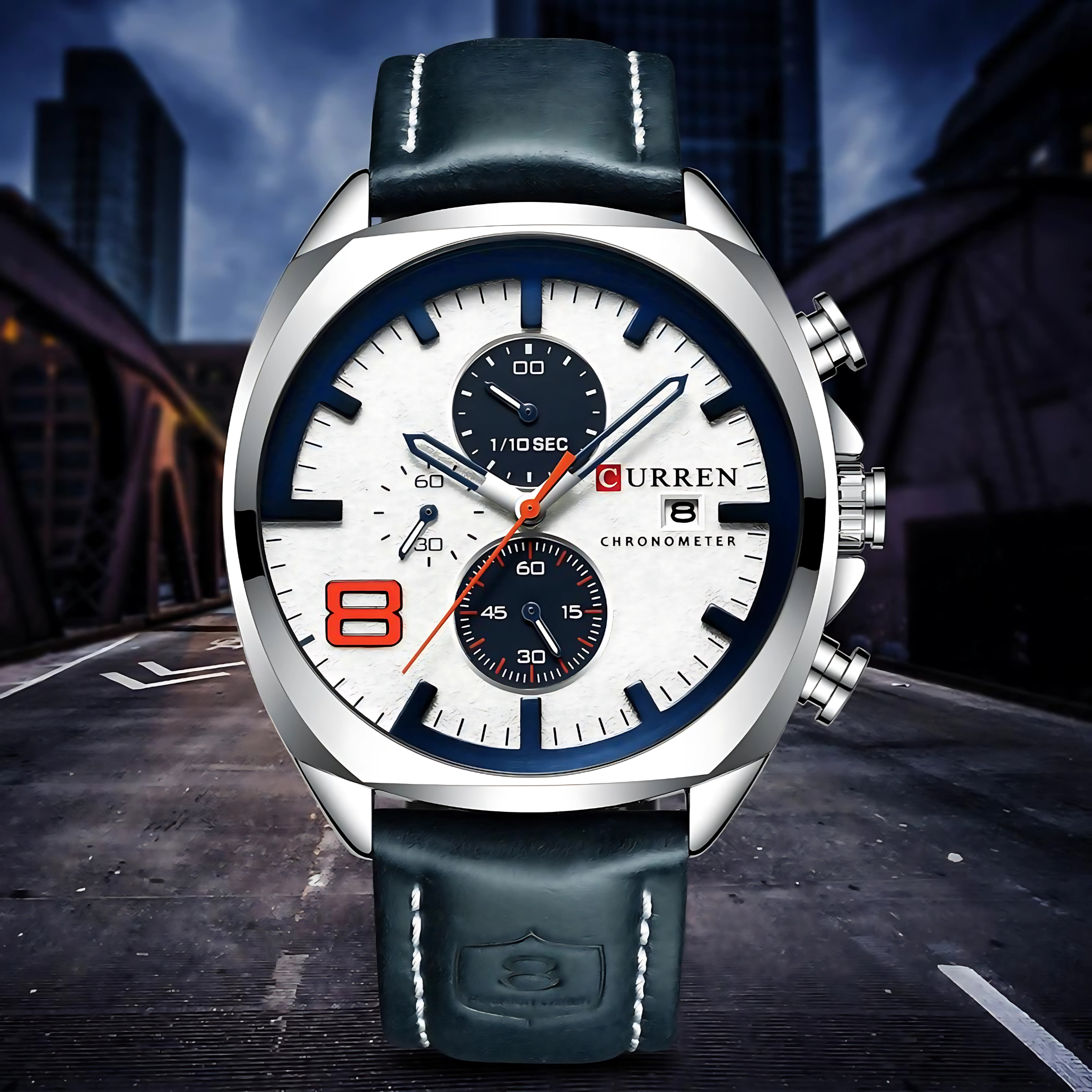 Nahaufnahme einer silbernen Uhr mit weißem Zifferblatt, schwarzen Hilfszifferblättern und blauem Lederarmband.