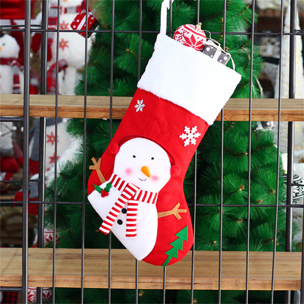 Roter Weihnachtsstrumpf mit Schneemann, Schneeflocken und Tannenbaumdesign, gefüllt mit Geschenken.
