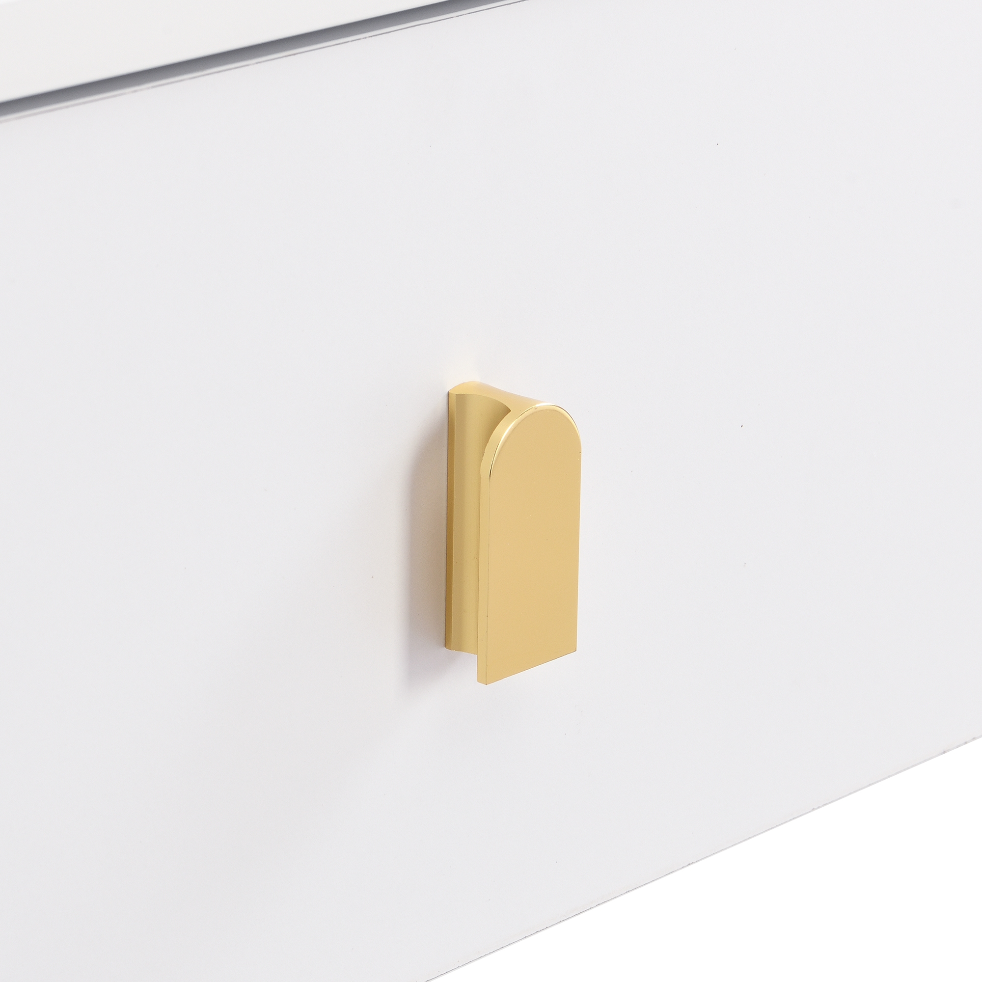 Weiße Schublade mit einem goldenen Griff. Der Griff ist ein gebogener, vertikaler Balken mit flacher Basis.