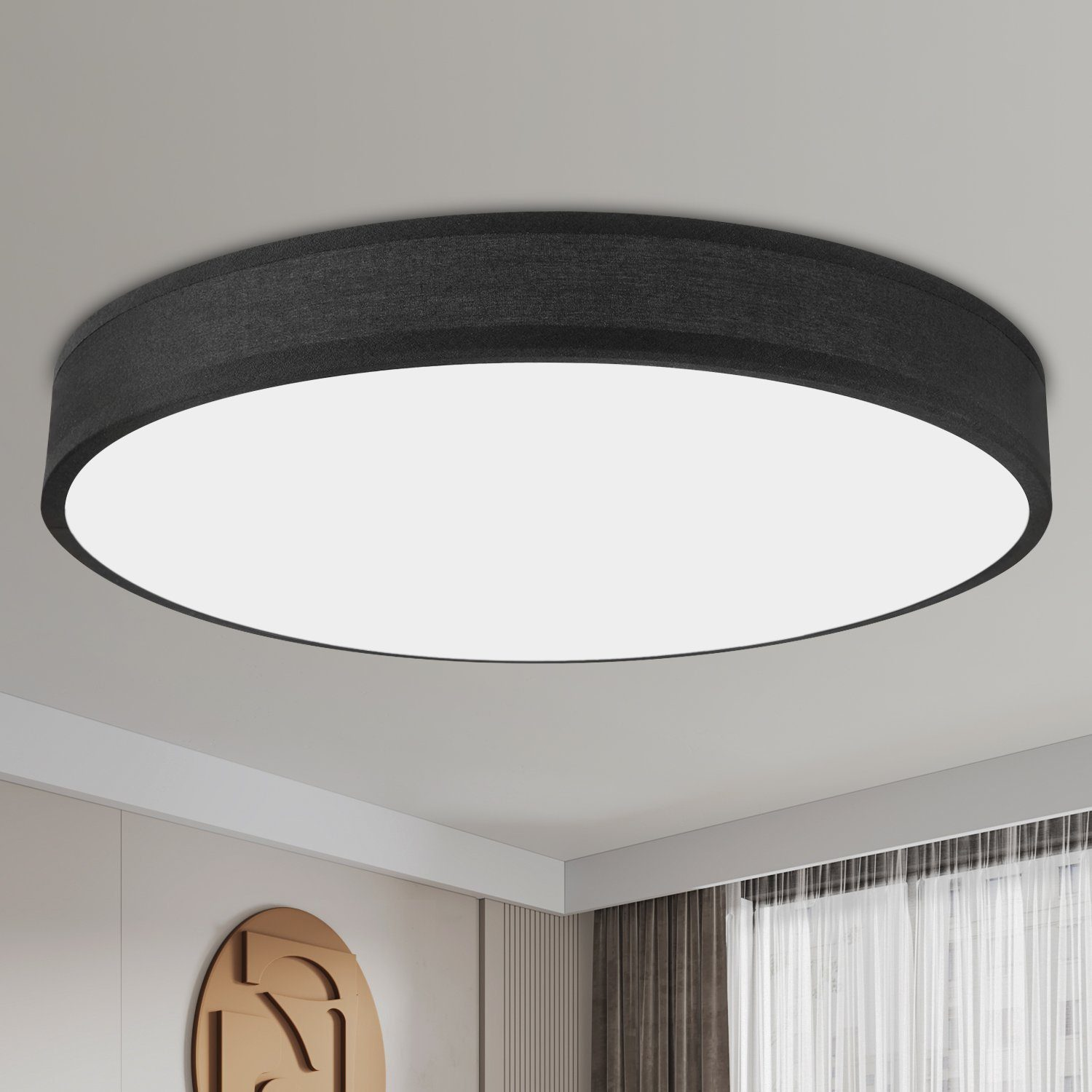 Eine Deckenleuchte, schwarzer Rand mit weißer Licht emittierender Oberfläche. Sauberes, modernes Design, an einer weißen Decke montiert.