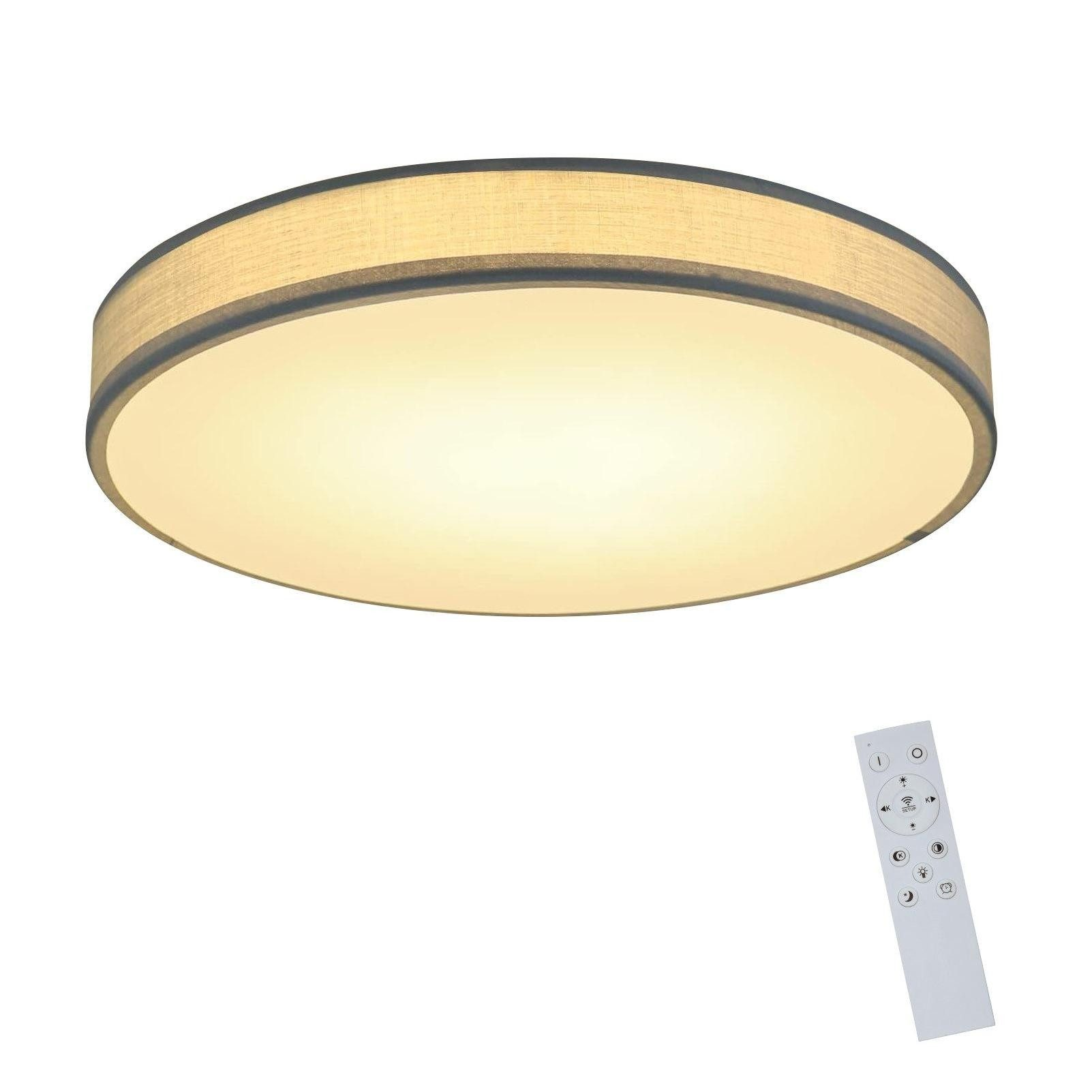 Okrągła lampa sufitowa z materiałowym abażurem i pilotem na białym tle.