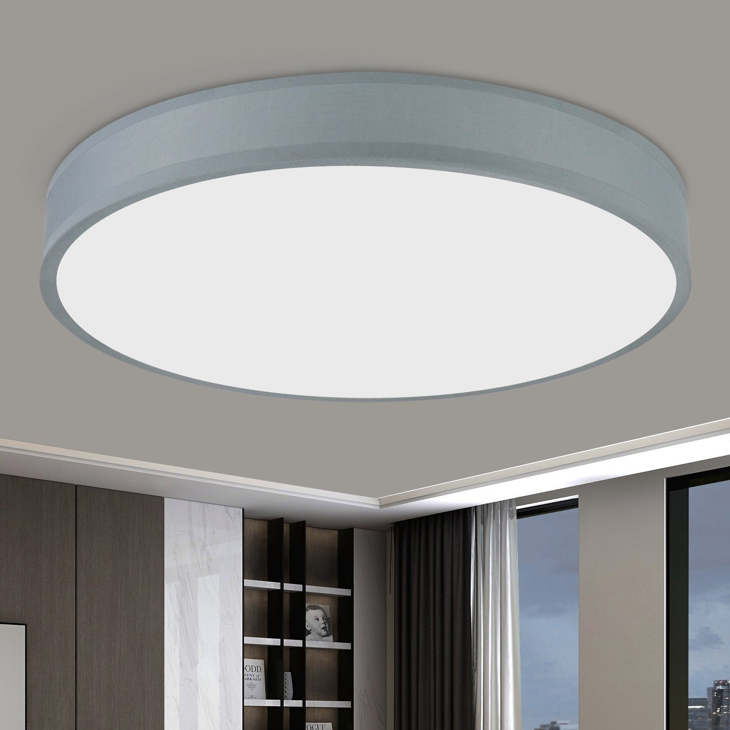 Okrągła, szara lampa sufitowa zamontowana na białym suficie. Pokój ma ciemne szafki i okno z zasłonami.