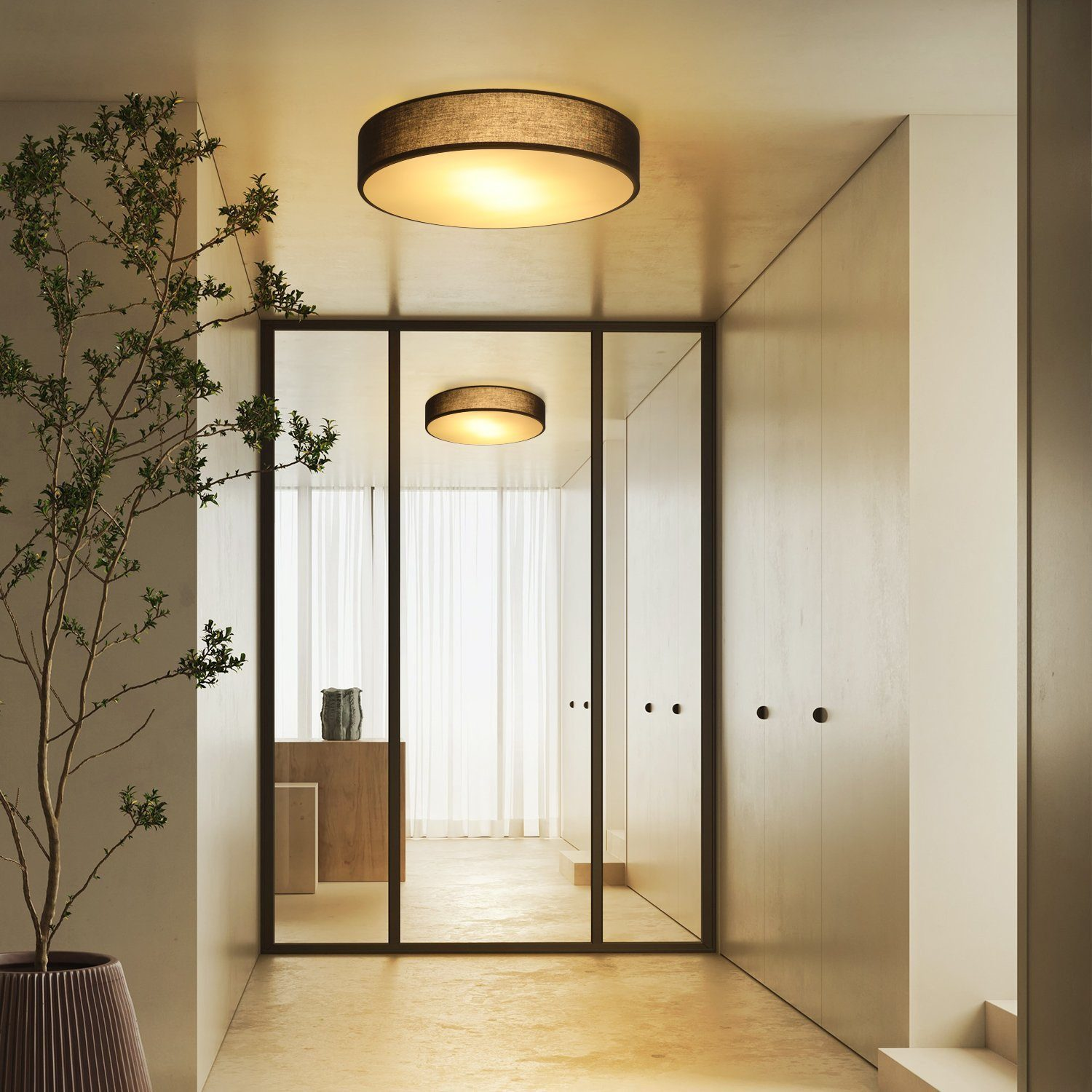 Nowoczesny korytarz z oprawą oświetleniową i lustrzaną ścianą. Beżowe ściany i neutralna kolorystyka.