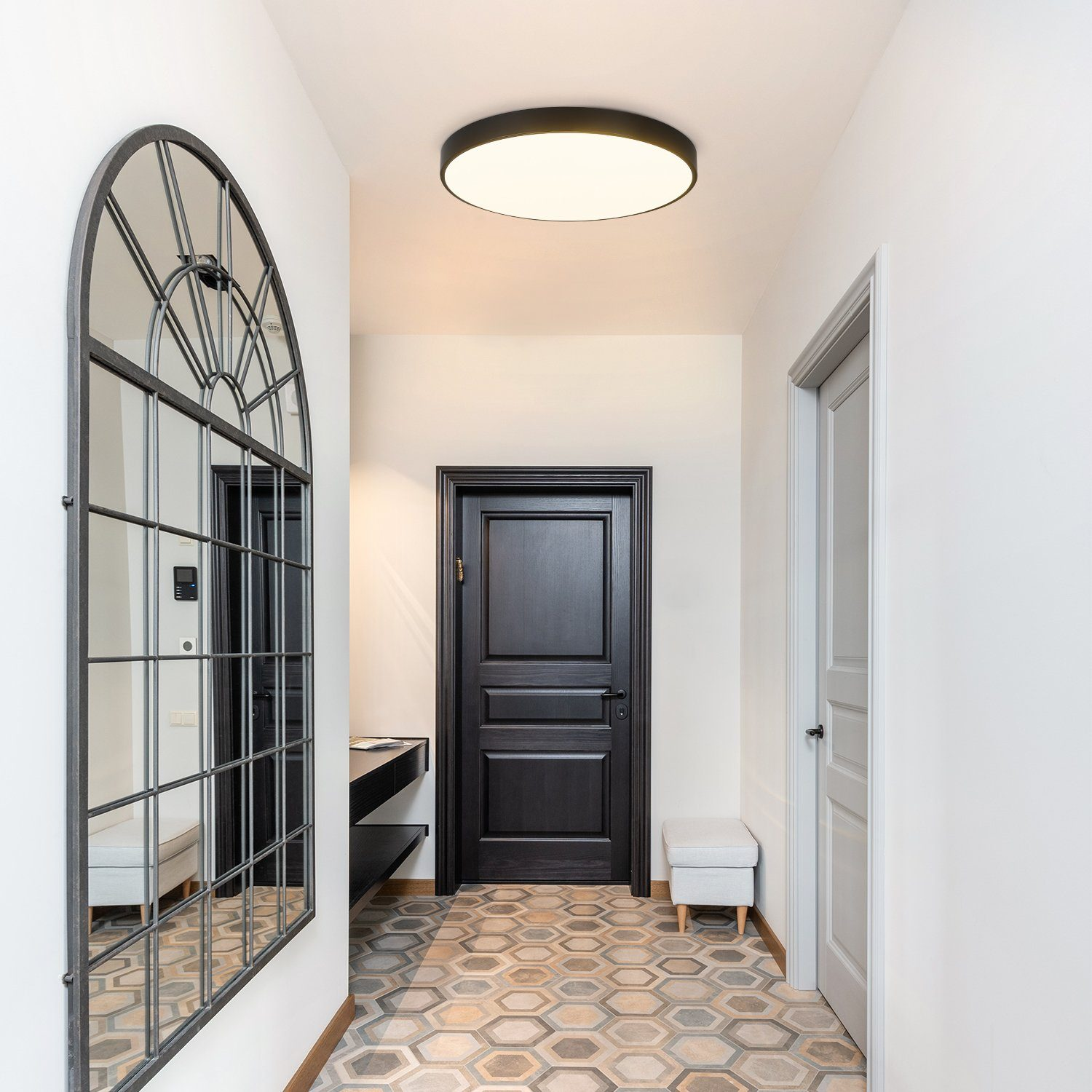 Korytarz z lustrem, drzwiami i oświetleniem sufitowym. Nowoczesny design z wzorzystą podłogą.