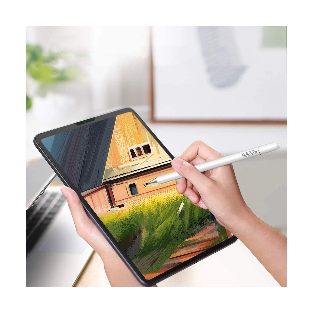 Eine Person zeichnet mit einem Stift auf einem Tablet, das eine Hausillustration zeigt.