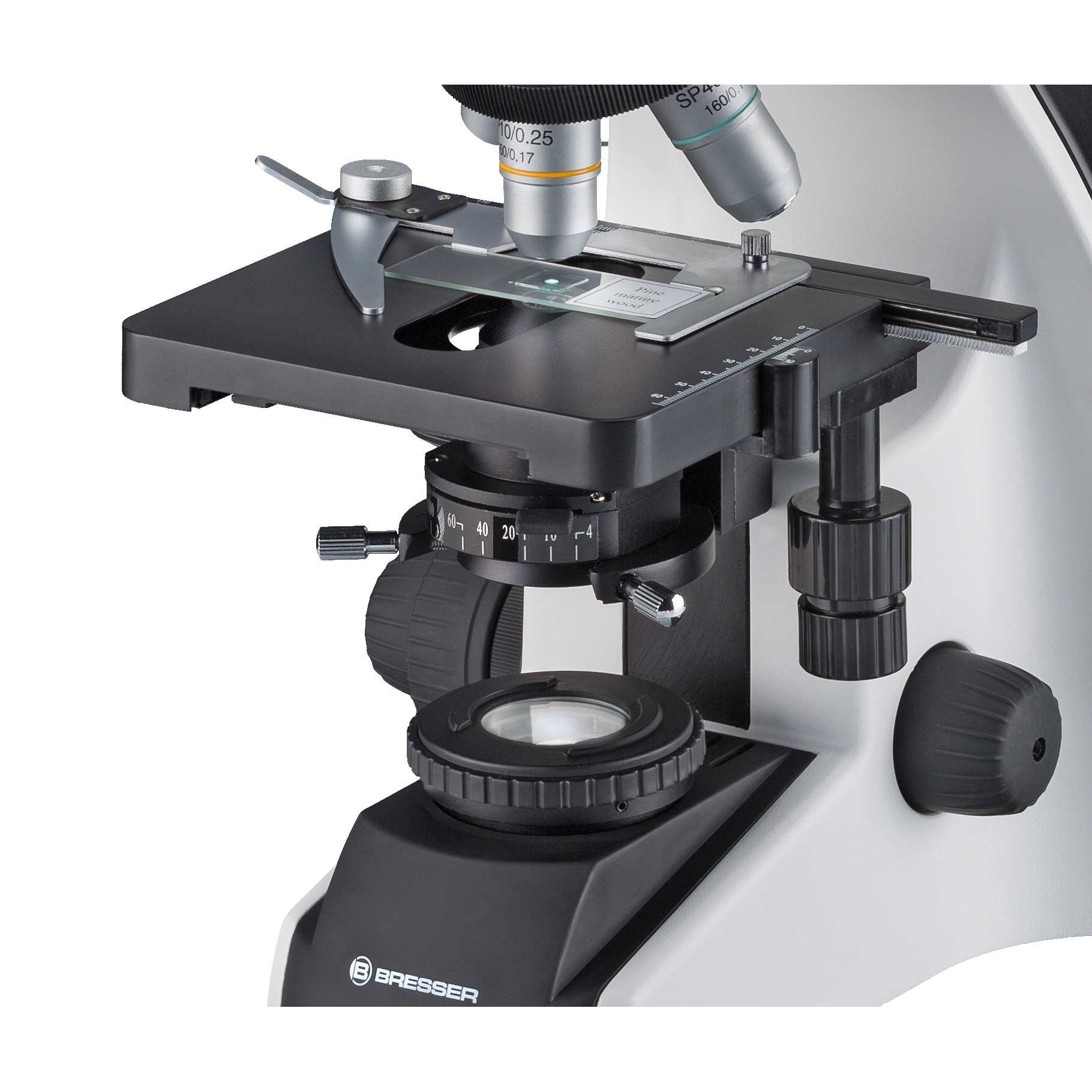 Microscopio, vista de cerca. Tiene lentes, una estructura en blanco y negro y un portaobjetos.