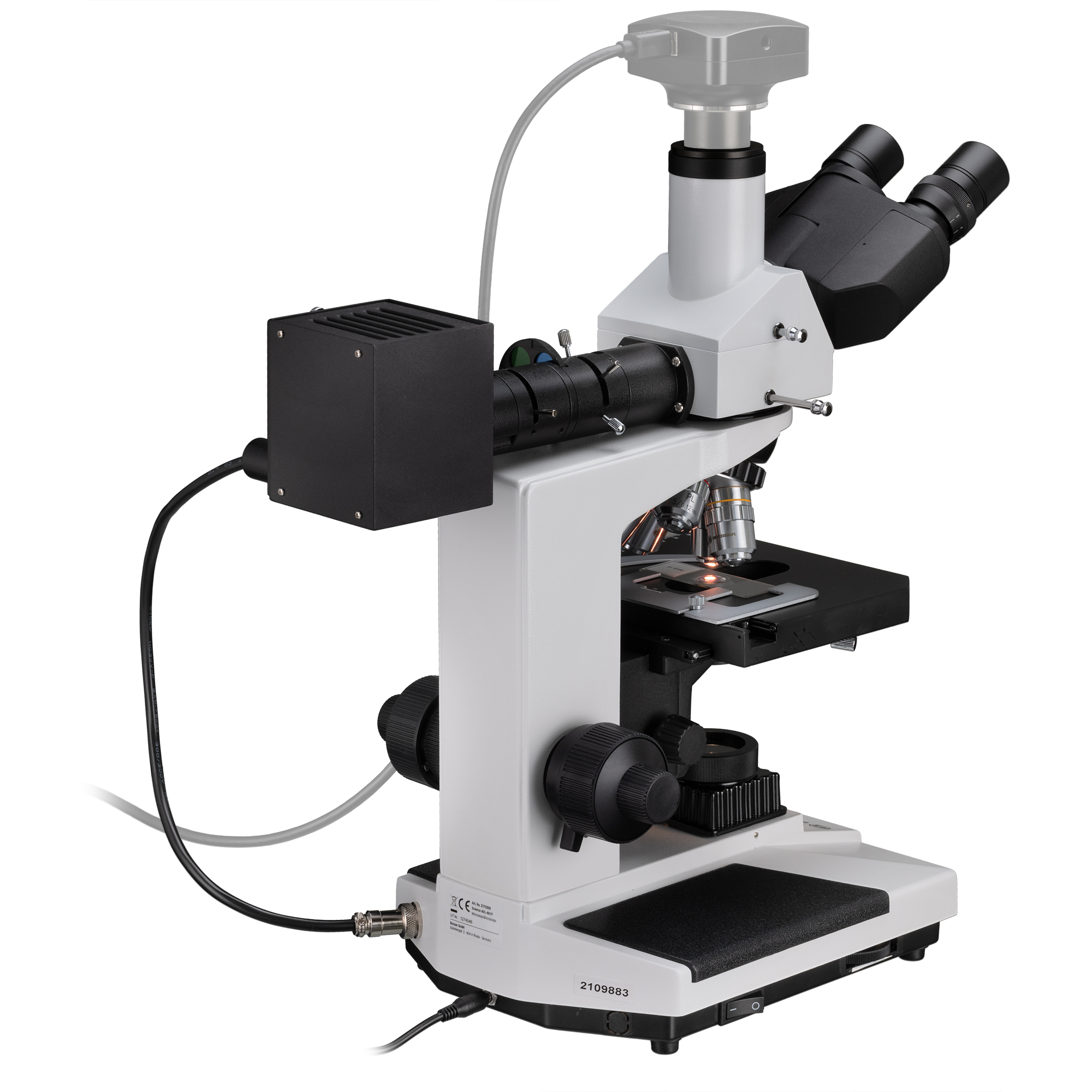 Un microscopio blanco y negro con un cable gris y una caja negra adjunta, aislado en blanco.