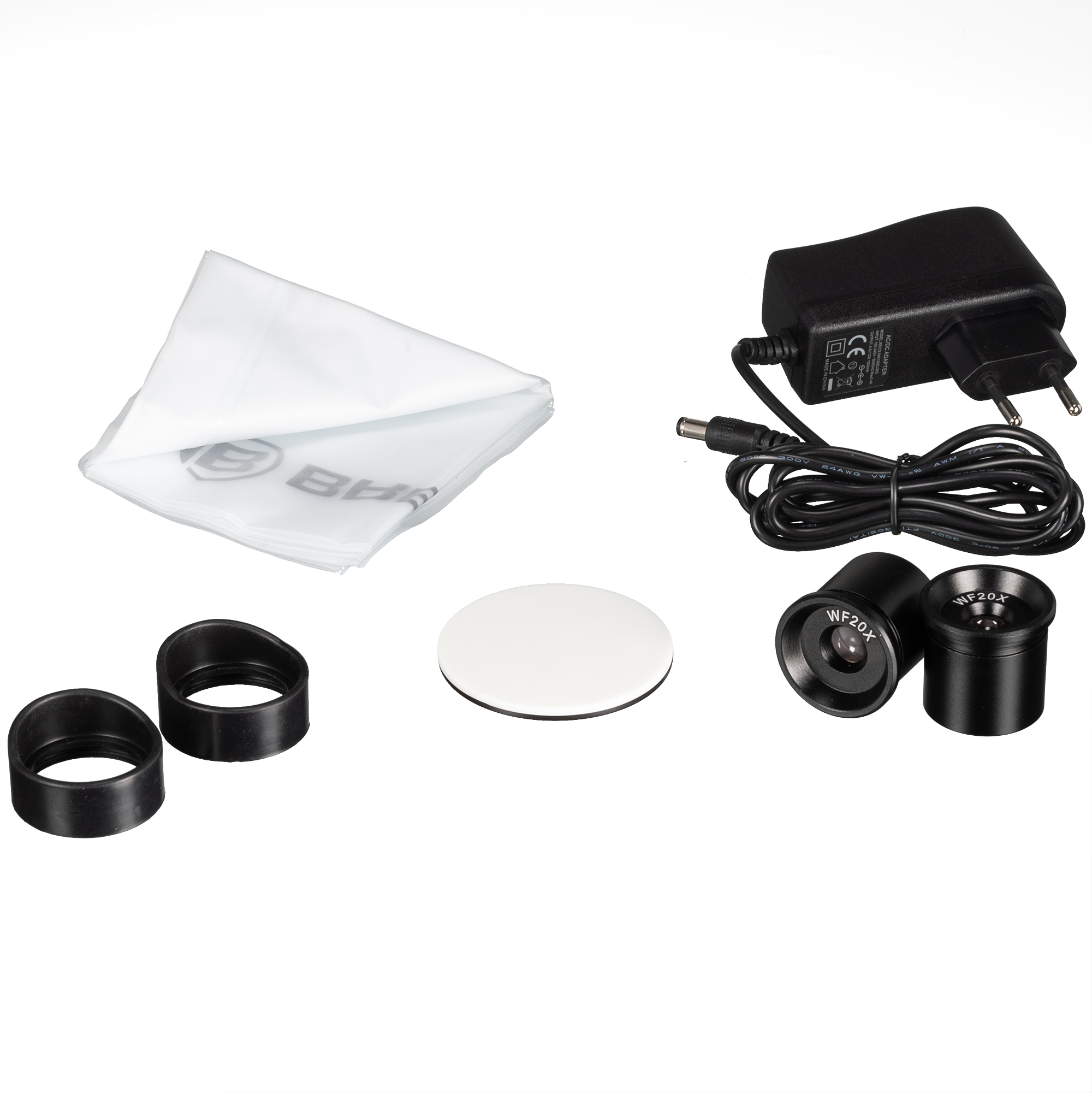 Accesorios de microscopio, incluyendo cargador, lente y paño de limpieza sobre blanco.