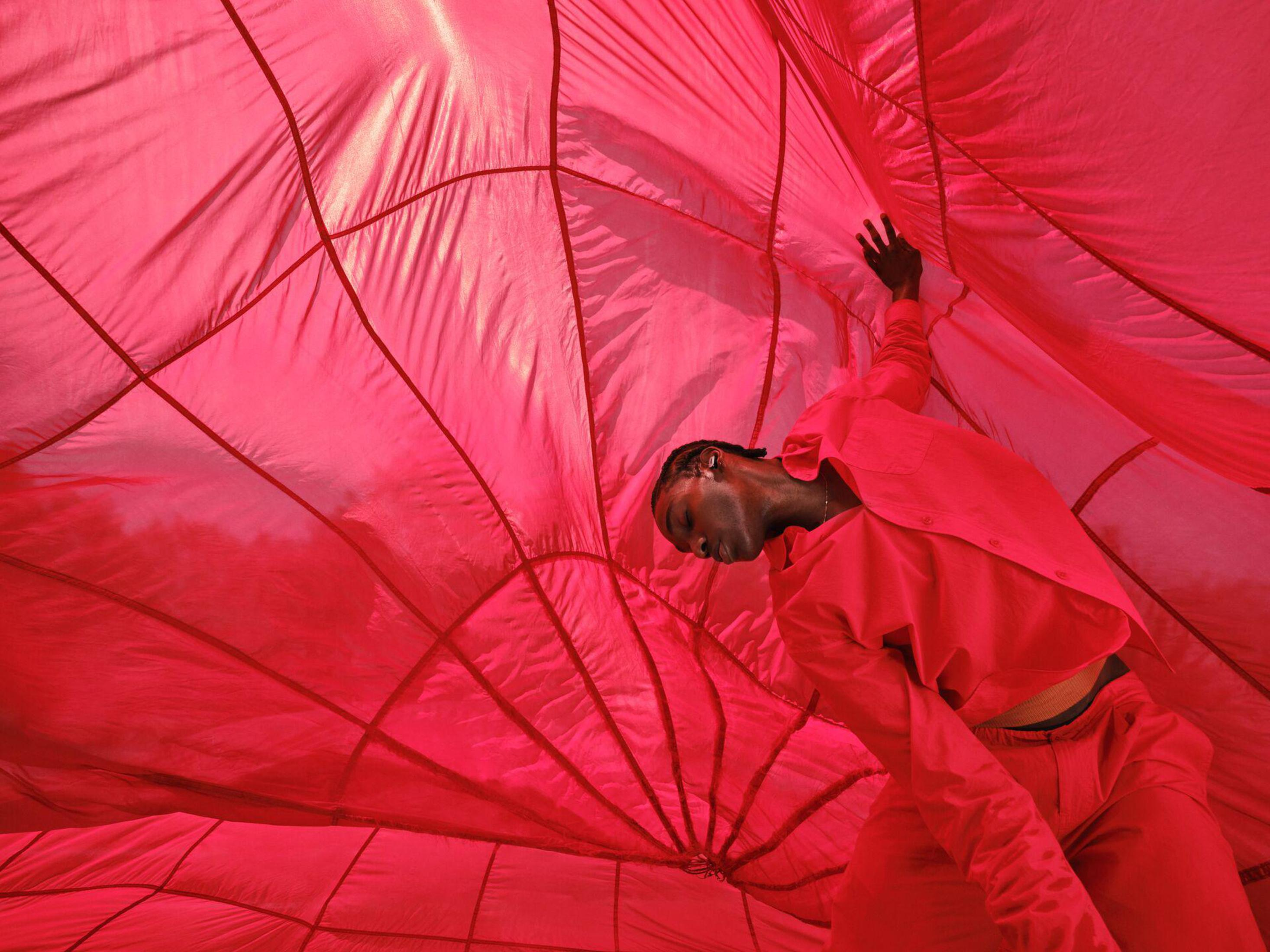 Osoba w czerwonych ubraniach wewnątrz dużego czerwonego balonu.
