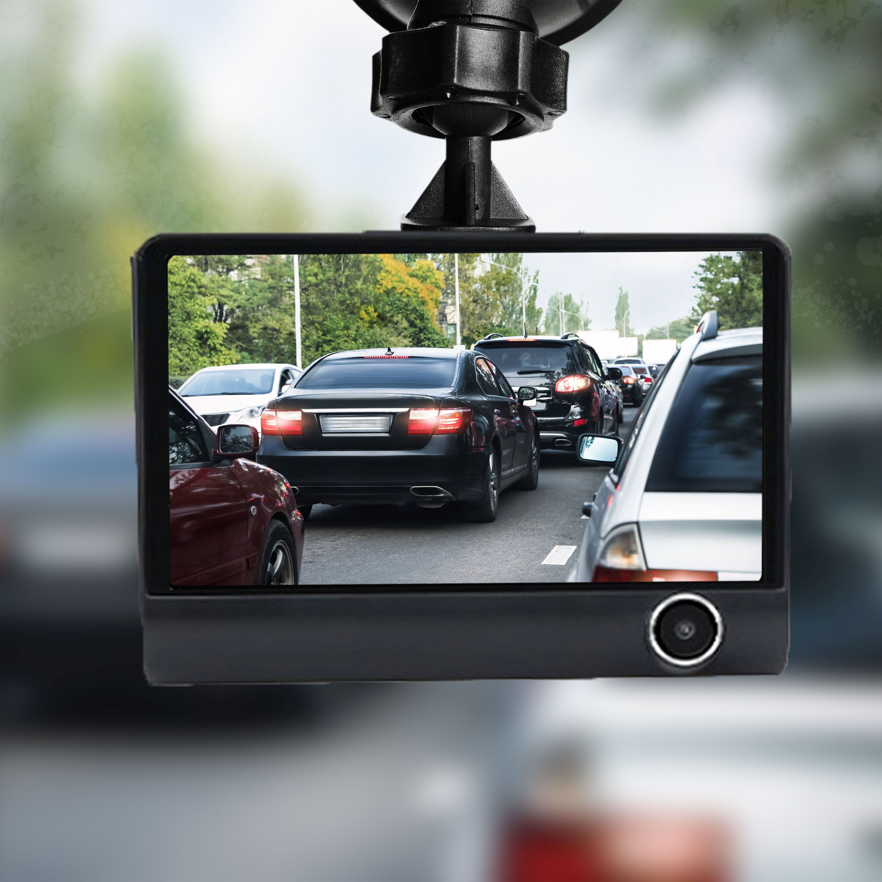 Eine Dashcam im Auto zeigt die Straße mit Verkehr. Ein verschwommener Hintergrund von Fahrzeugen ist sichtbar.