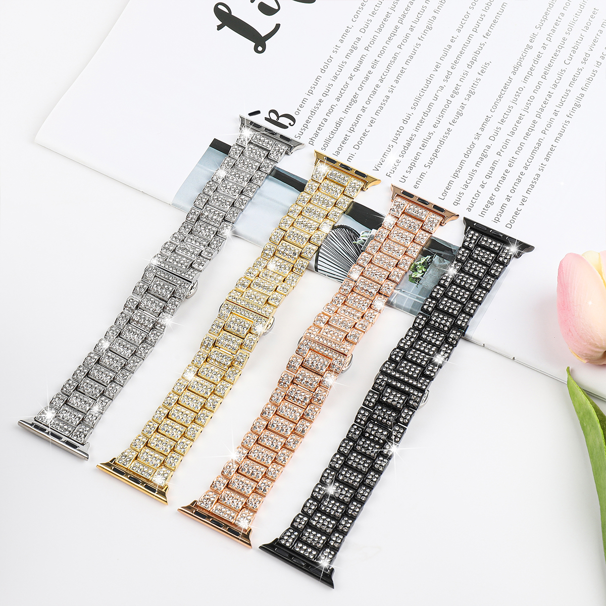 Vier Uhrenarmbänder mit Strasssteinen, in Silber, Gold, Roségold und Schwarz.