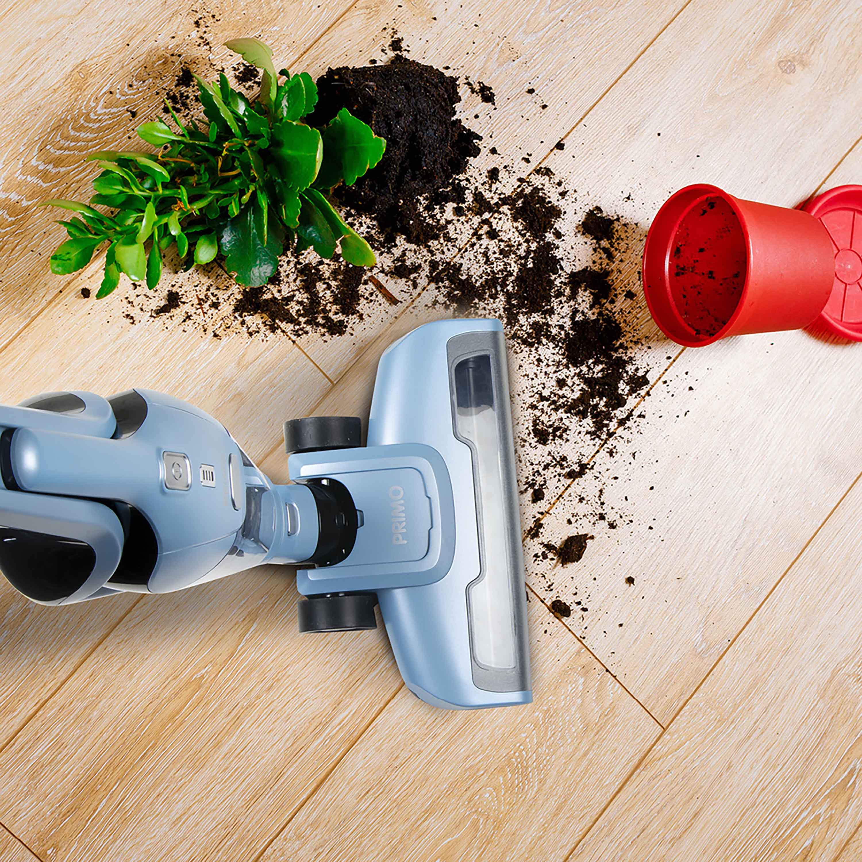Tête d'aspirateur bleue sur plancher en bois à côté de terre renversée, d'une plante et d'un pot rouge.