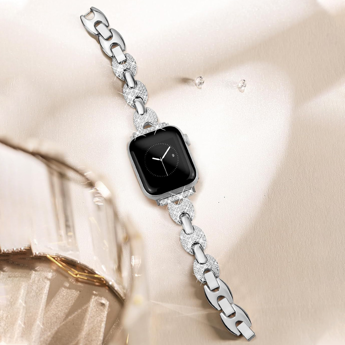 Silberne Uhr mit diamantbesetztem Armband vor verschwommenem Hintergrund. Kleine Diamanten sind verstreut.