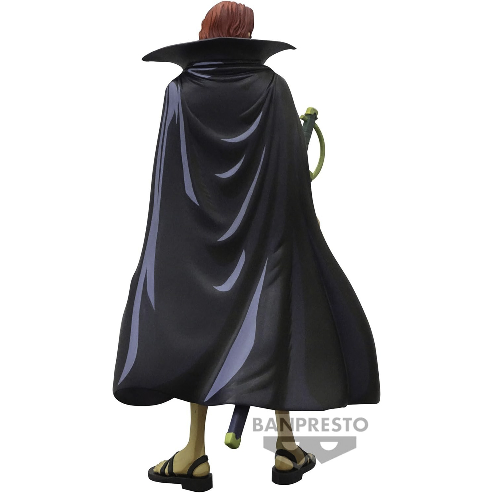 Una figura de un hombre con capa negra y sandalias. Tiene pelo rojo.