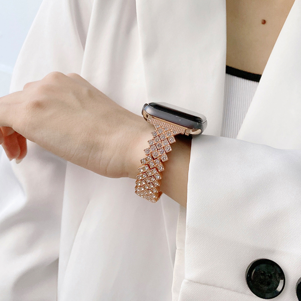 Ein Handgelenk mit einer Hand, die eine roségoldene Uhr mit einem verzierten Band trägt.