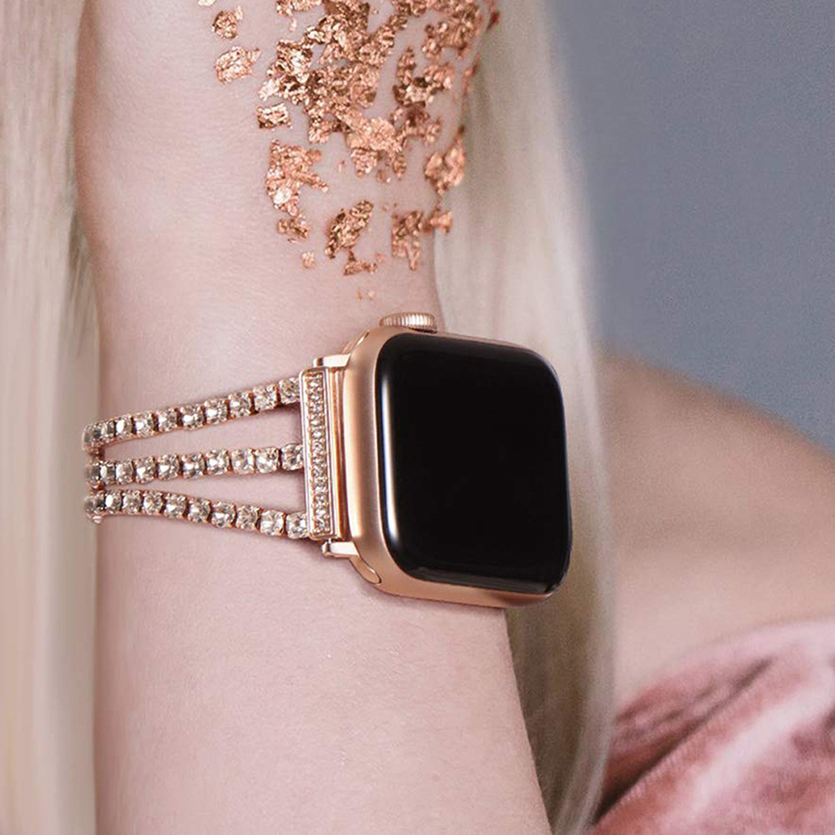 Eine roségoldene Apple Watch am Handgelenk mit Strassband.
