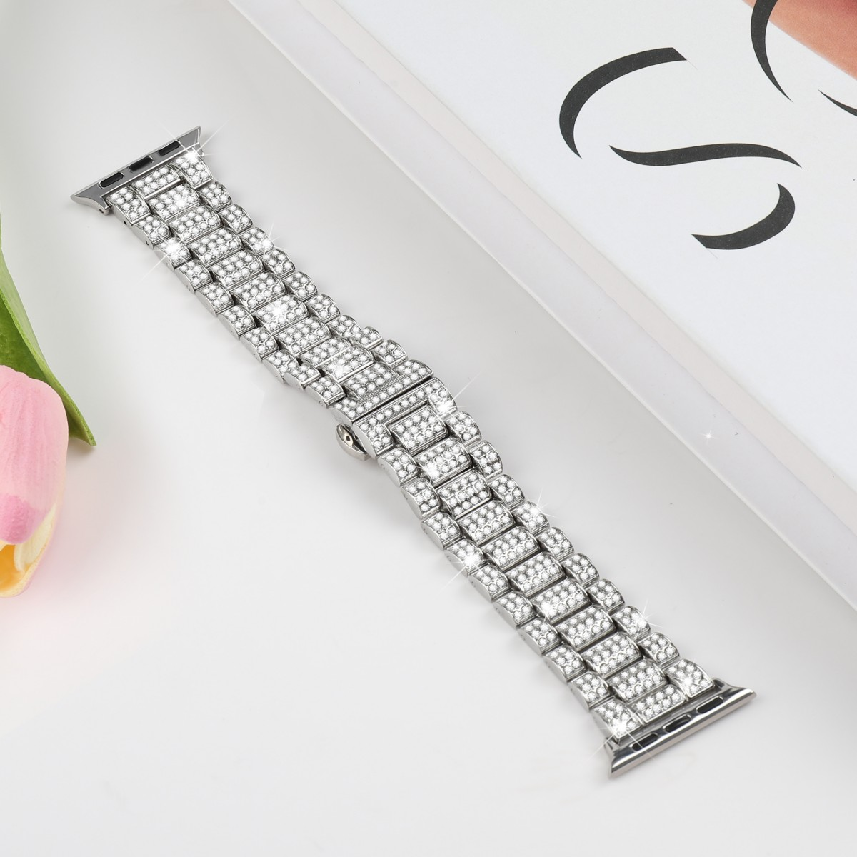 Ein Uhrenarmband mit glänzenden Kristallen in einem silbernen Metallrahmen.