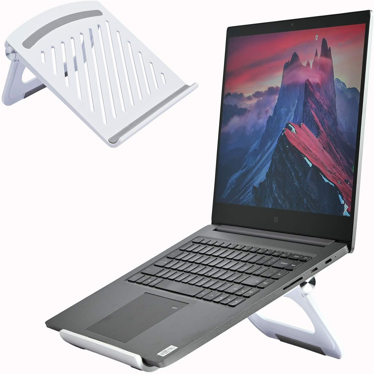 Laptop auf weißem Ständer. Ein zusätzlicher Ständer ist separat. Berglandschaft auf dem Bildschirm.