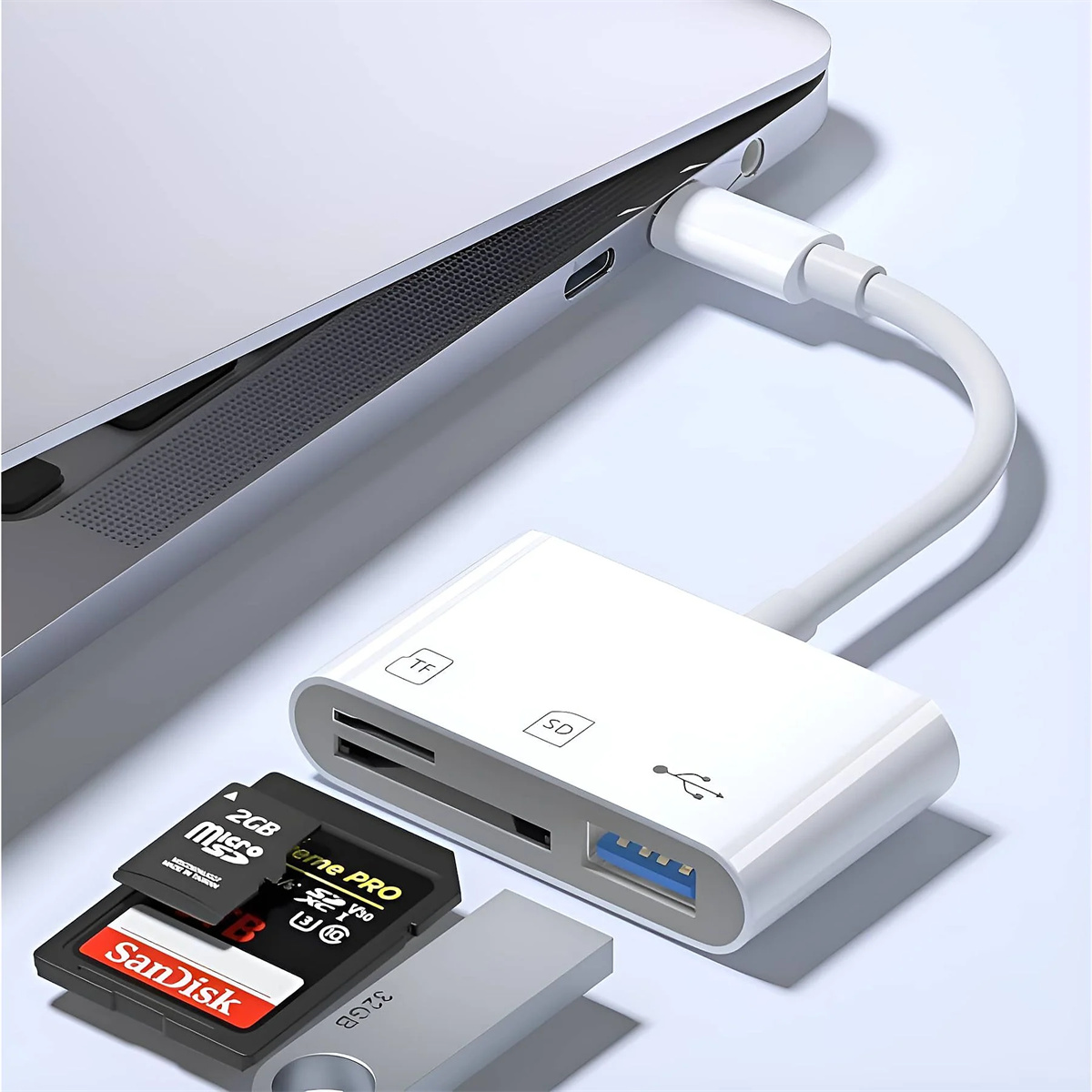Weißer USB-Hub mit angeschlossenen SD-Karten und einem USB-Stick neben einem Laptop, auf heller Oberfläche.