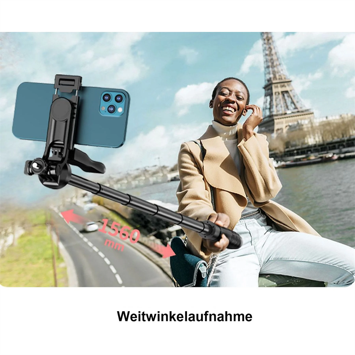 Frau macht Selfie mit Handy auf Selfie-Stick, mit Fluss und Gebäuden im Hintergrund.