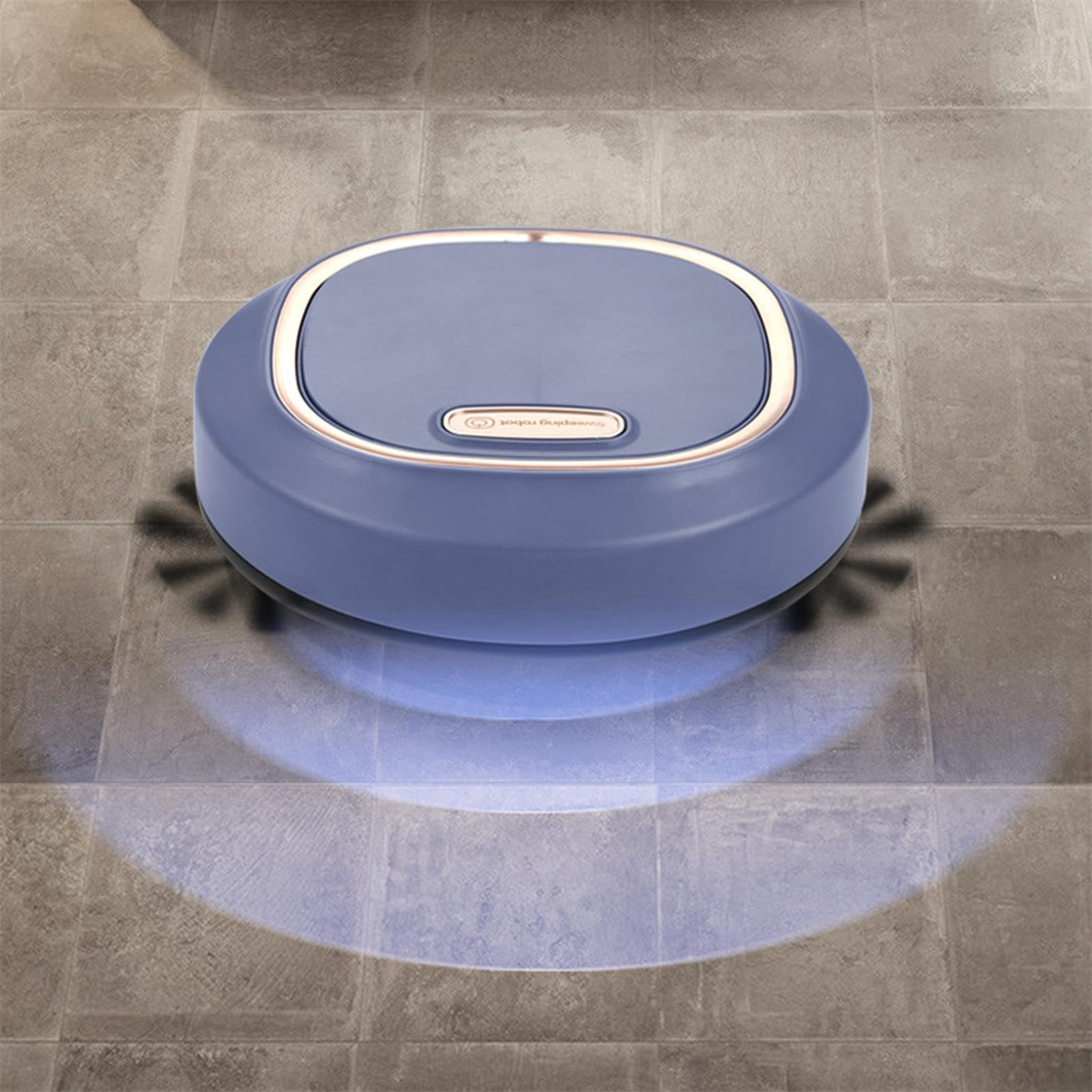 Ein blau-grauer Roboter-Staubsauger auf einem gefliesten Boden, mit Licht von unten.