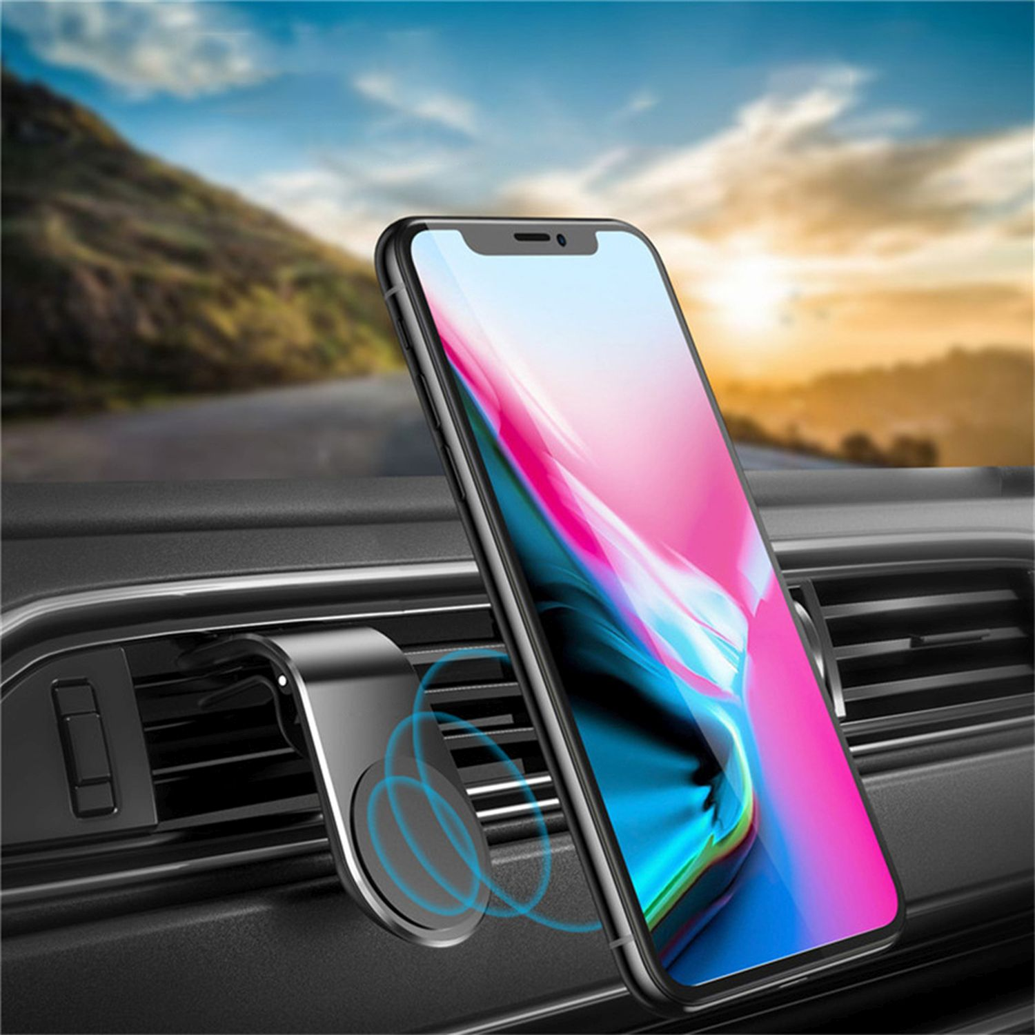 Telefon an einer Autoentlüftung montiert. Das Telefon zeigt einen bunten Bildschirm, Bergstraße im Hintergrund.