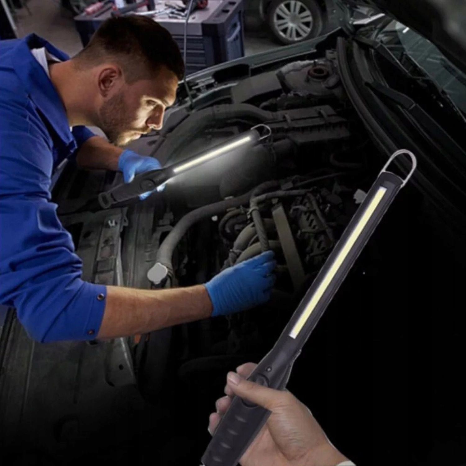Mann mit blauen Handschuhen inspiziert Motor mit Arbeitslicht. Ein weiteres Licht ist zu sehen.
