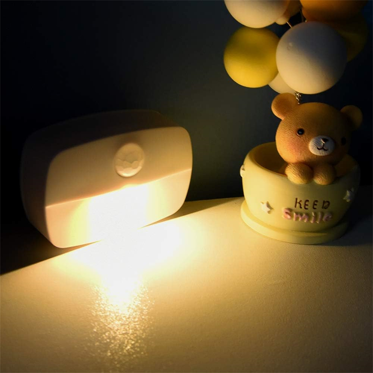 Eine Lampe beleuchtet einen kleinen Bären in einer Tasse mit Lichtquelle.