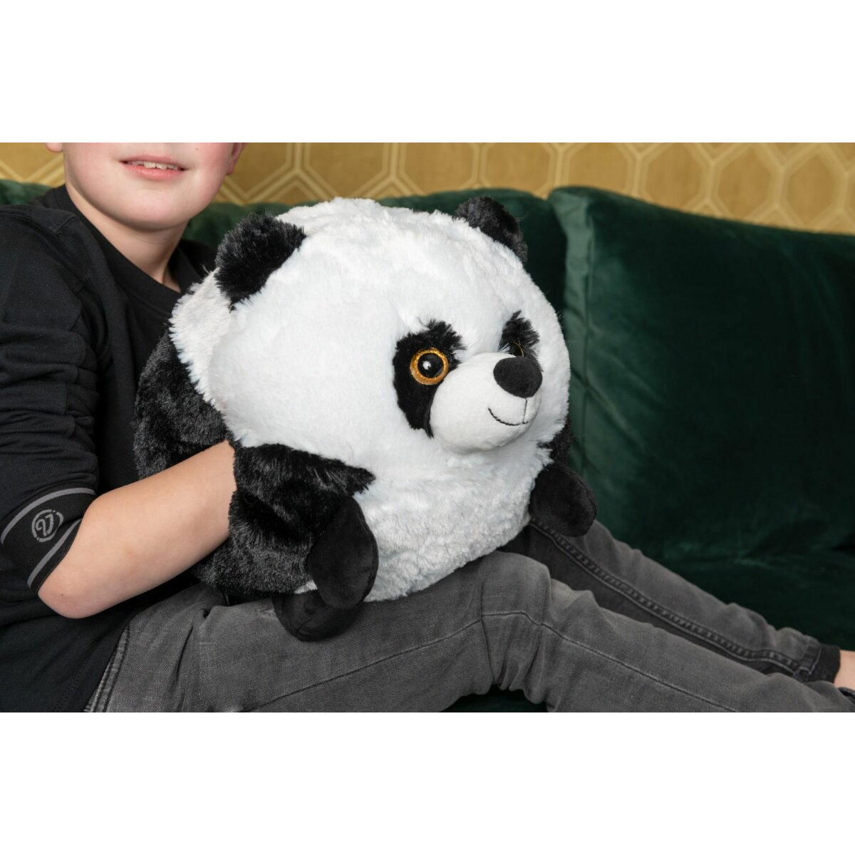 Ein Junge, der ein Panda-Plüschtier auf dem Schoß hält.