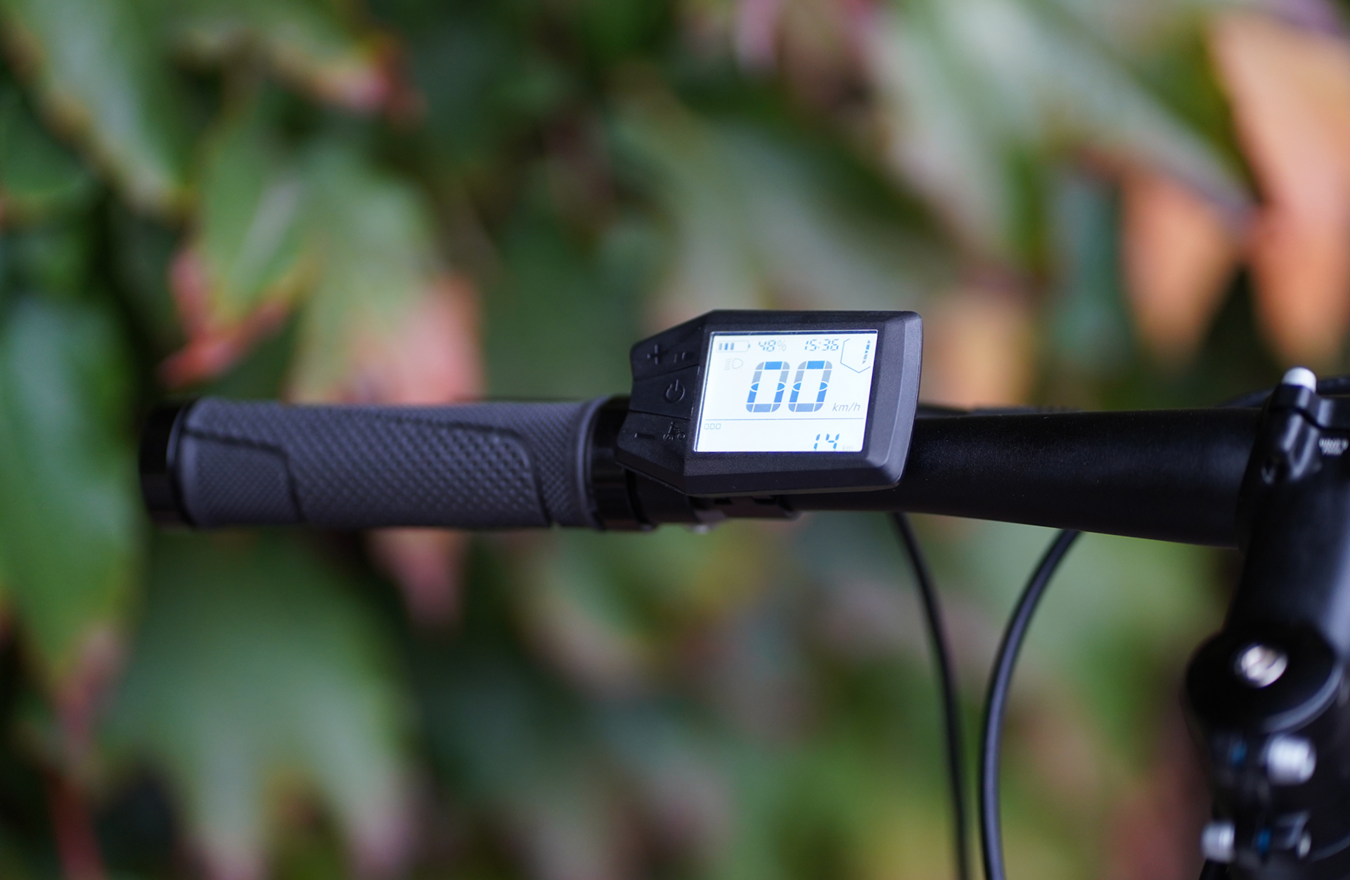Lenker eines Fahrrads mit digitaler Anzeige, die 48% Akku, 15:35 Uhr und 00 km/h anzeigt.