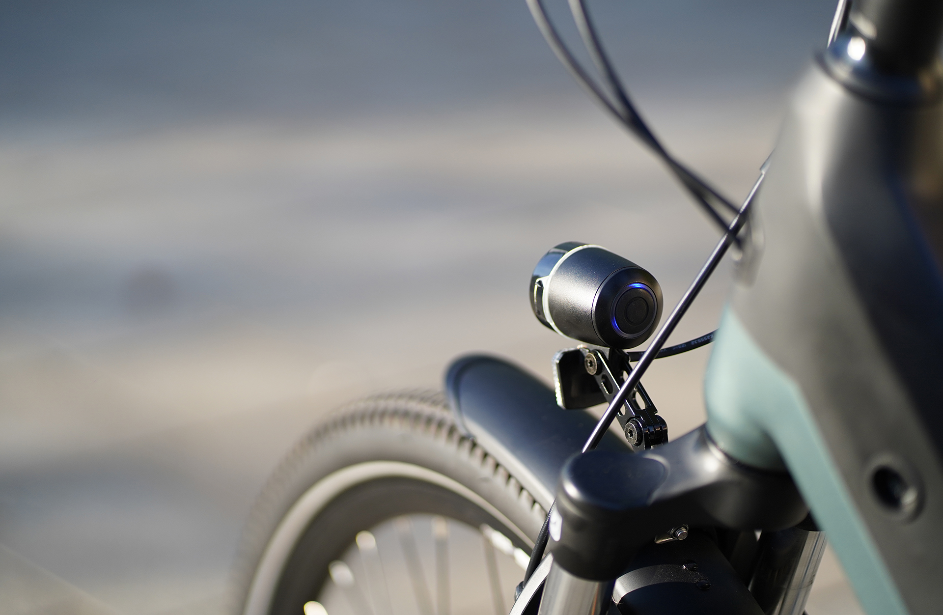 Nahaufnahme einer schwarzen Kamera, die vorne am Fahrrad über dem Vorderrad montiert ist.