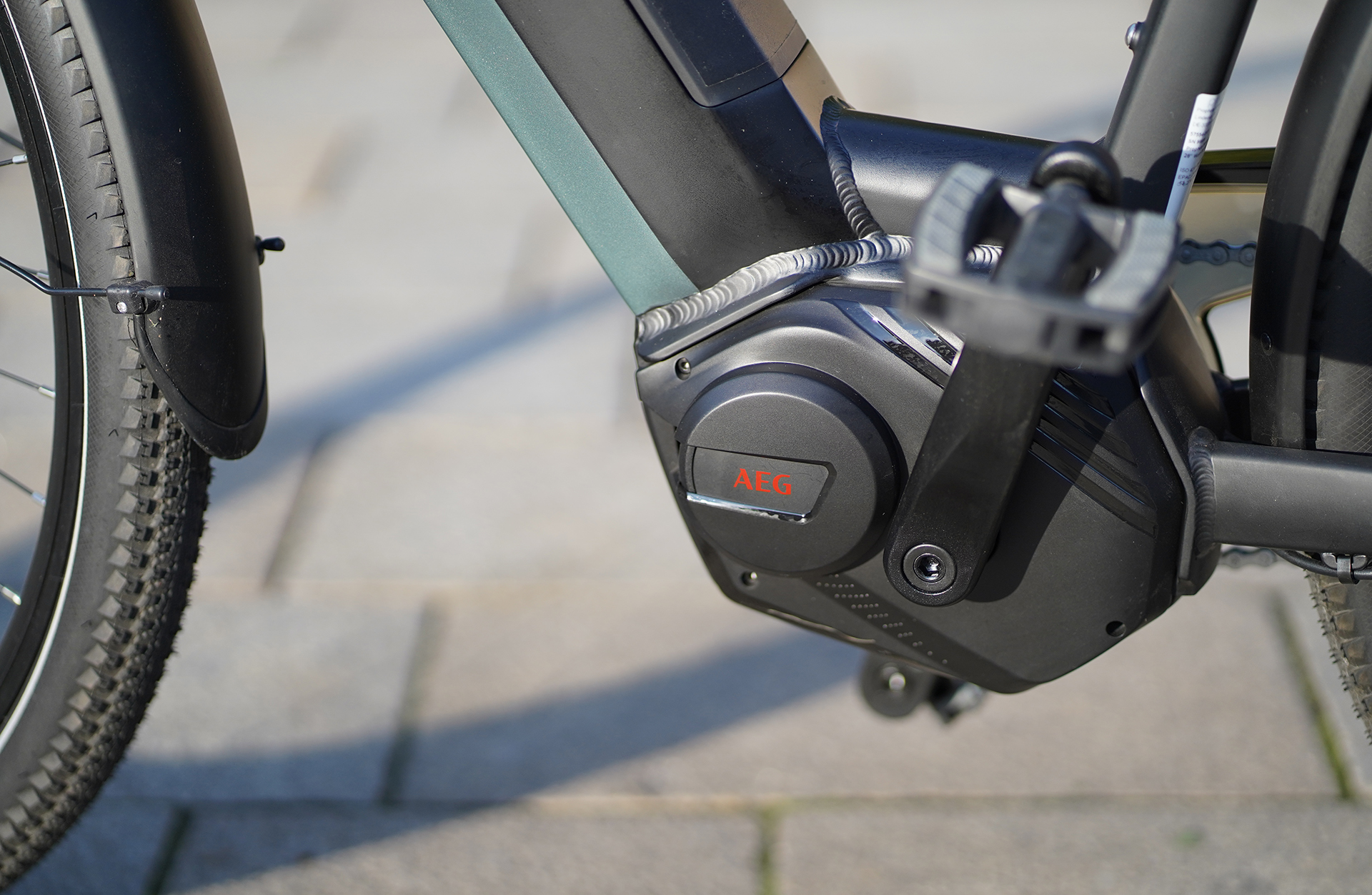 Nahaufnahme des Fahrradmotors mit dem 'AEG'-Logo auf einem schwarz-grauen Gehäuse.