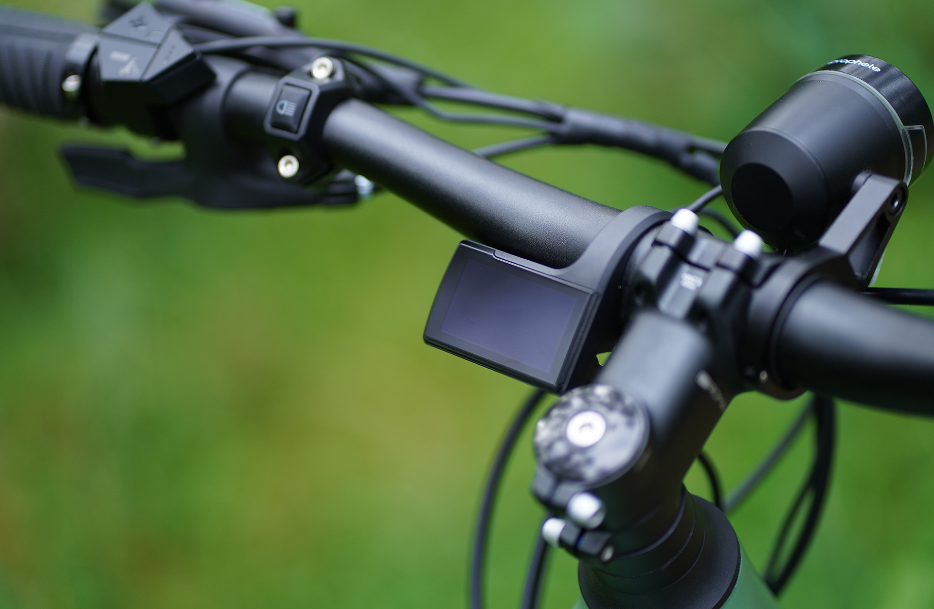 Nahaufnahme des Lenkers eines Elektrofahrrads mit Display und Licht.