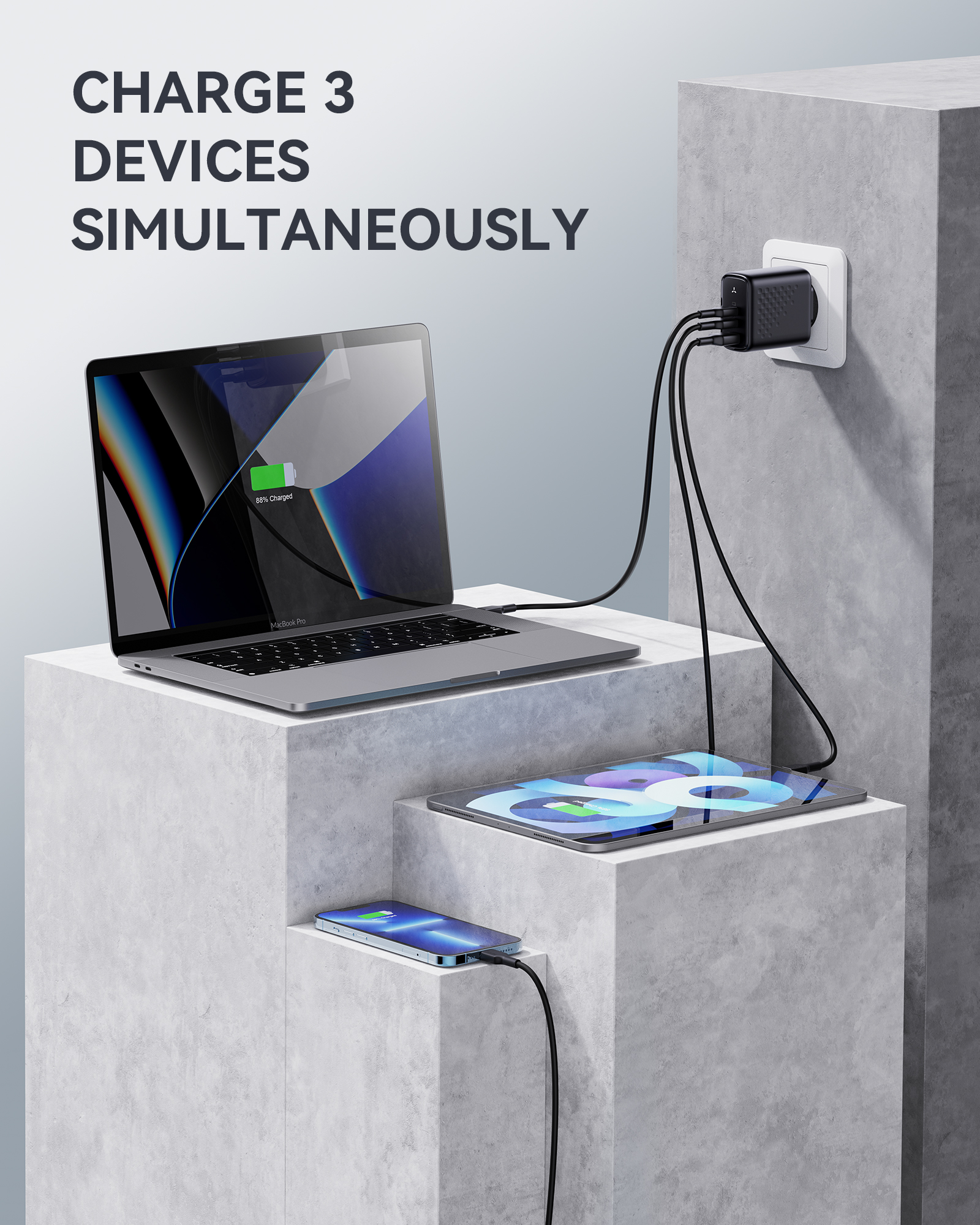 Tres dispositivos cargando. Un portátil, una tableta y un teléfono se están cargando simultáneamente.