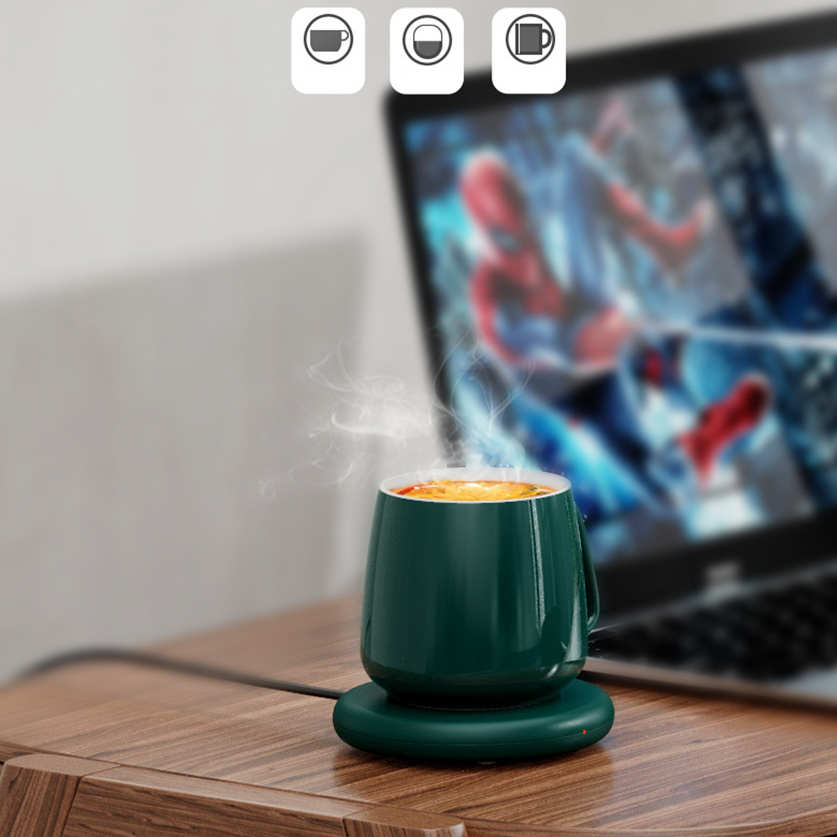 Eine Tasse Kaffee mit Dampf auf einem grünen Wärmer, im Hintergrund ein Laptop.