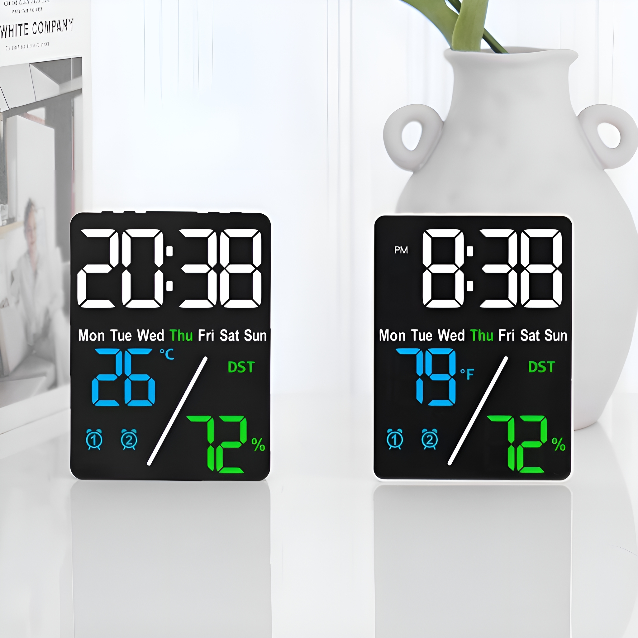 Zwei Digitaluhren, die Zeit, Temperatur und Luftfeuchtigkeit anzeigen. Eine ist Celsius, die andere Fahrenheit.