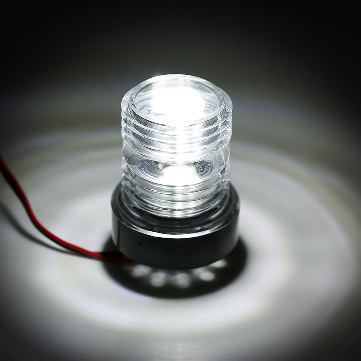 Helles, klares Licht, zylindrische Form, mit rotem Draht, vor dunklem Hintergrund.