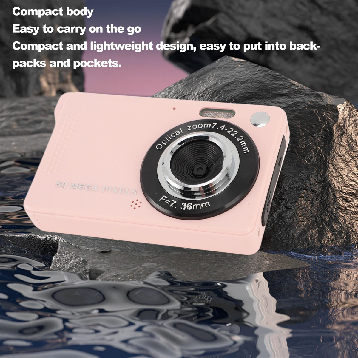 Eine rosa Digitalkamera mit schwarzem Objektiv auf einer wasserähnlichen Oberfläche und einem Steinhintergrund. Es steht 50 Megapixel.