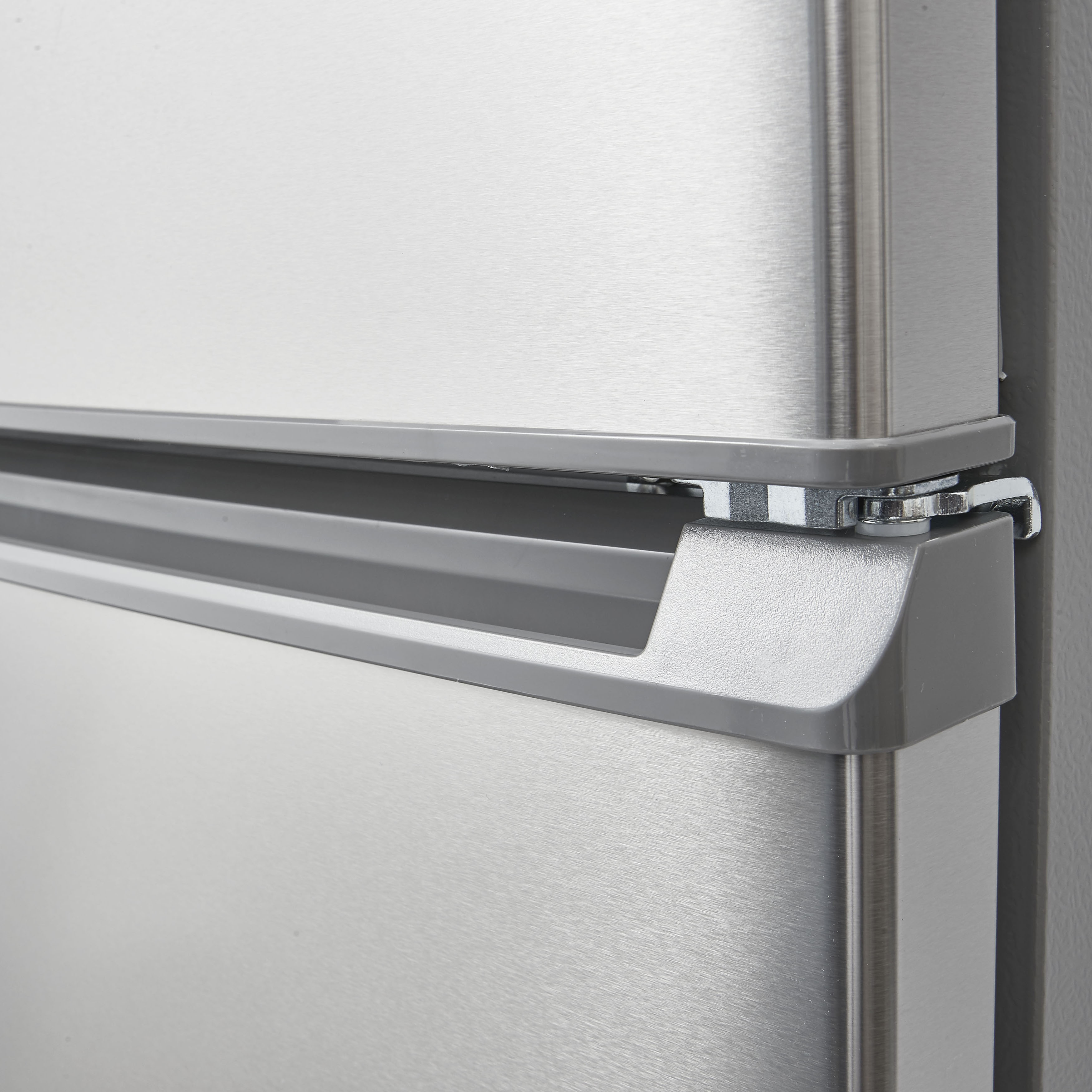 Close-up of a refrigerator door handle, gray, on a stainless steel surface.