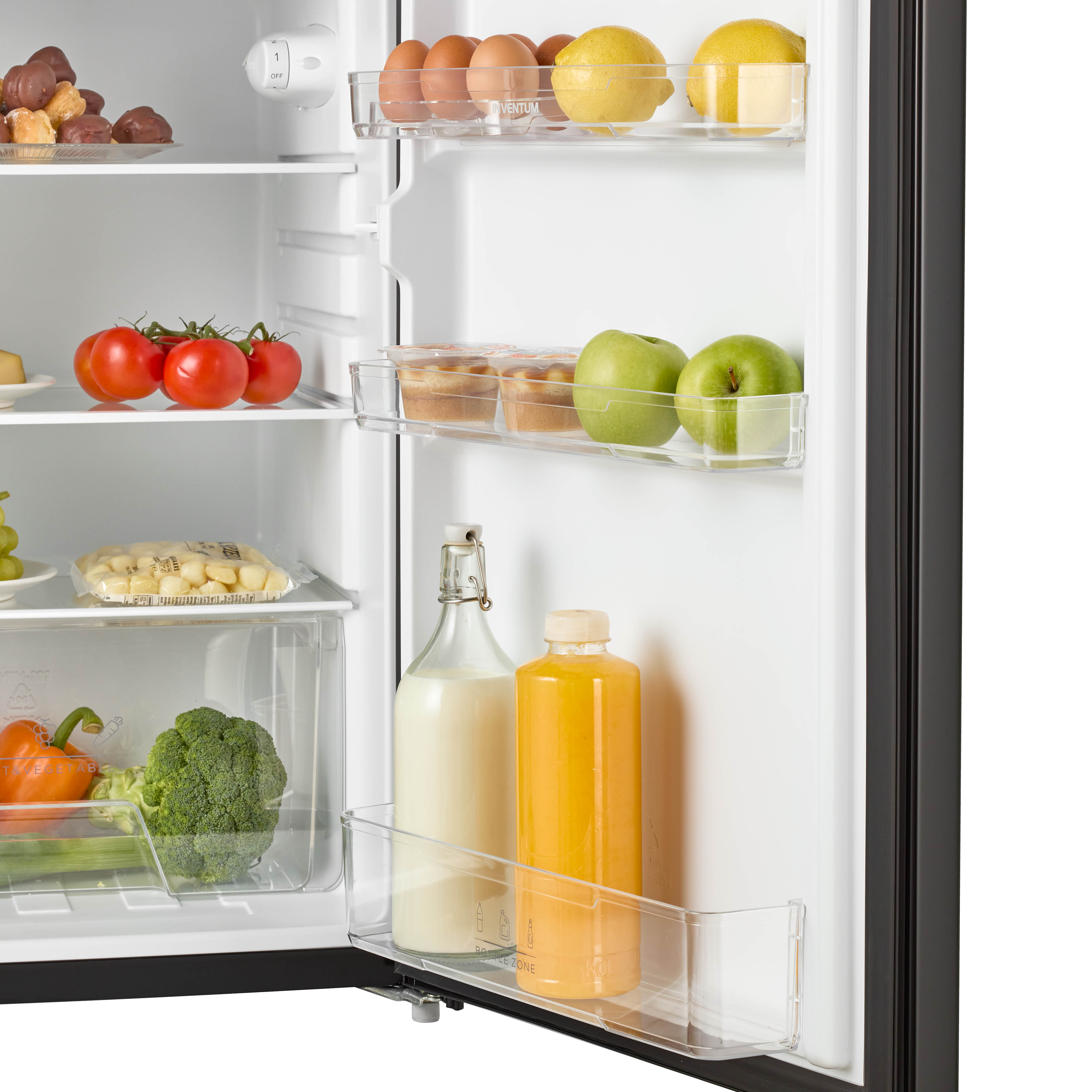 Refrigerator interior showing food items like eggs, lemons, juice, and vegetables.