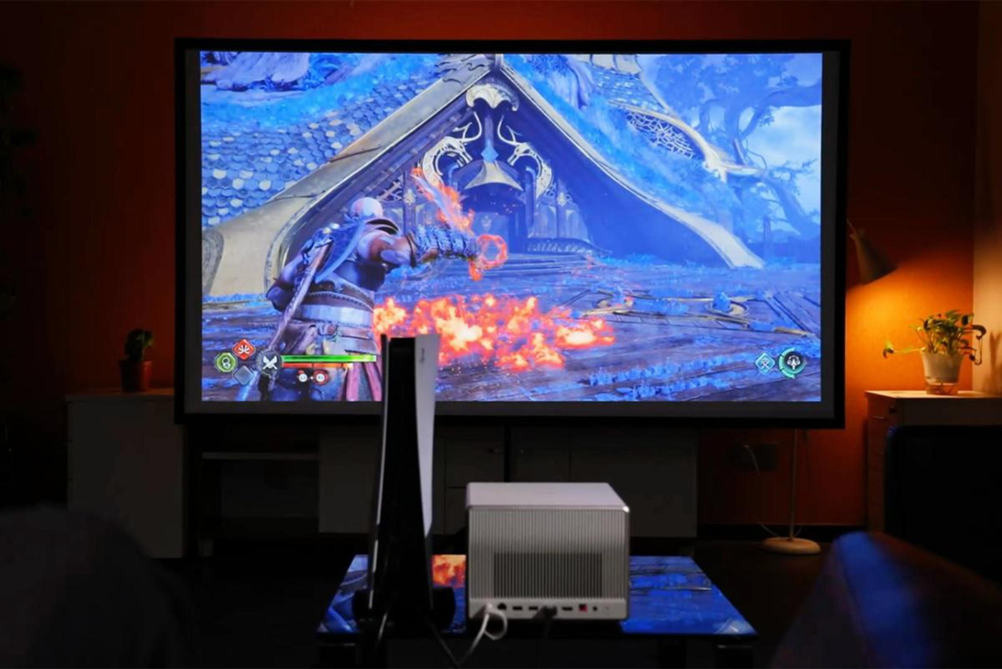 Konfiguracja do gier: duży ekran, konsola i małe białe pudełko.