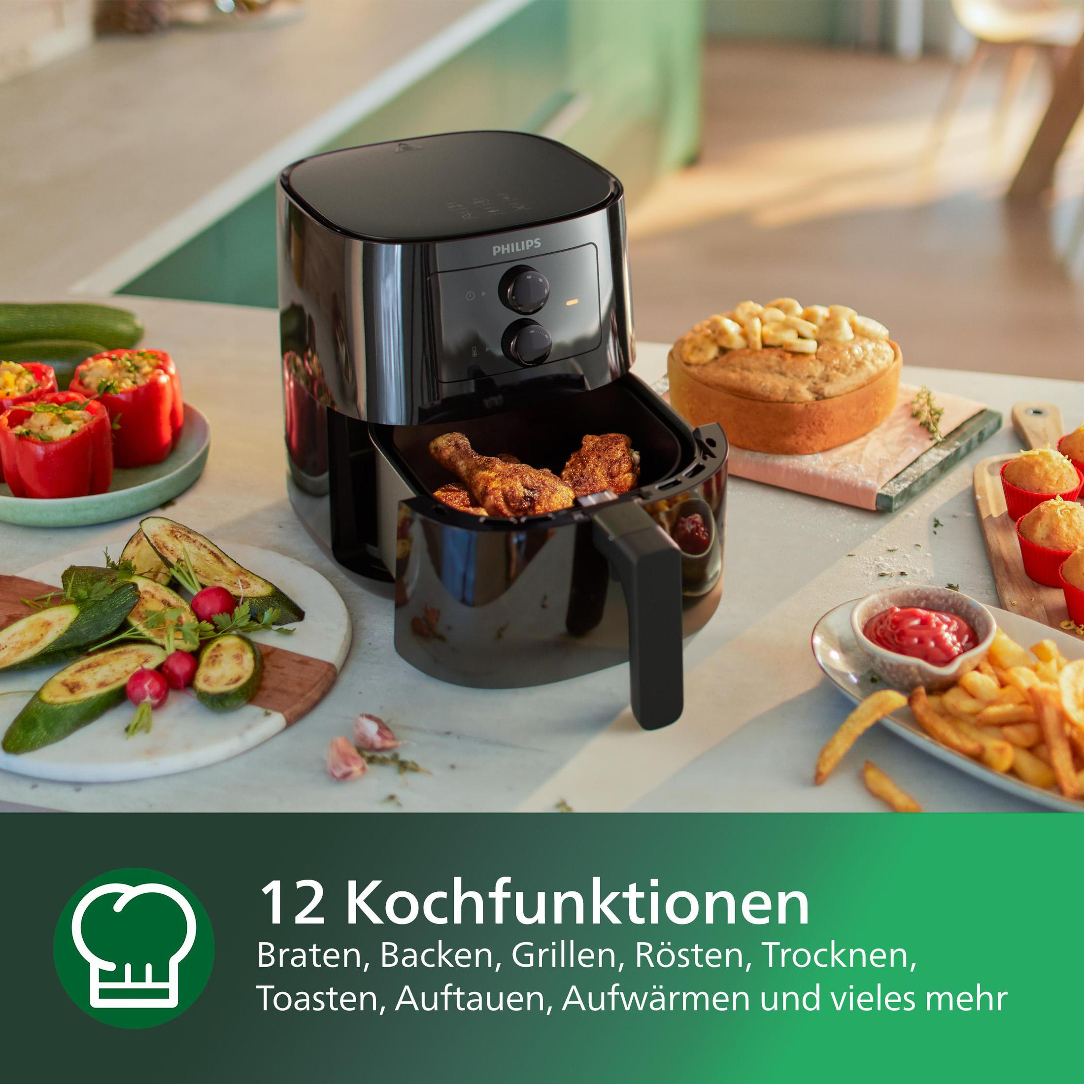 Freidora de aire Philips negra con comida frita. También hay otros alimentos, como calabacín y un pastel.