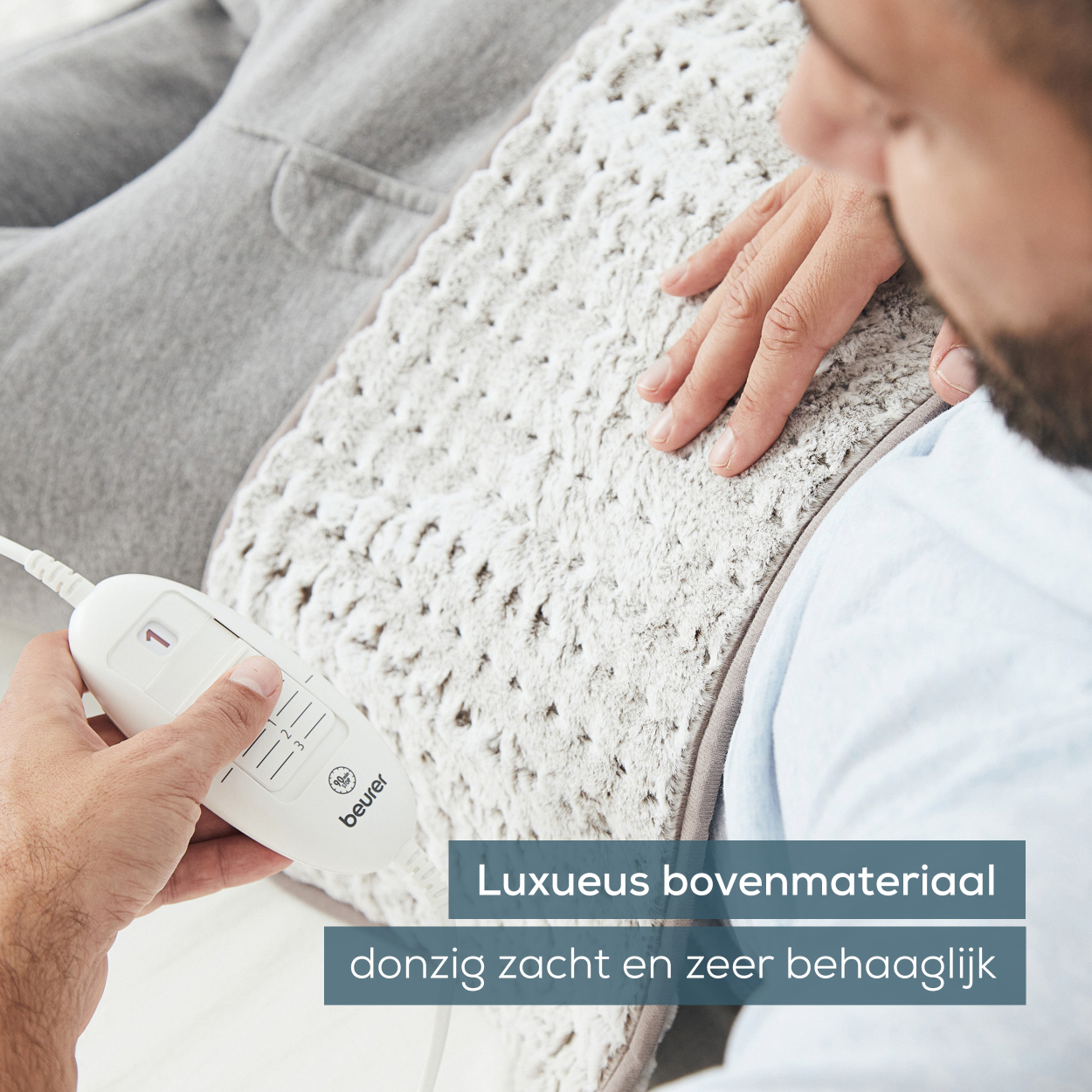 Man gebruikt warmtekussen, wit kussen en bediening. Witte achtergrond.