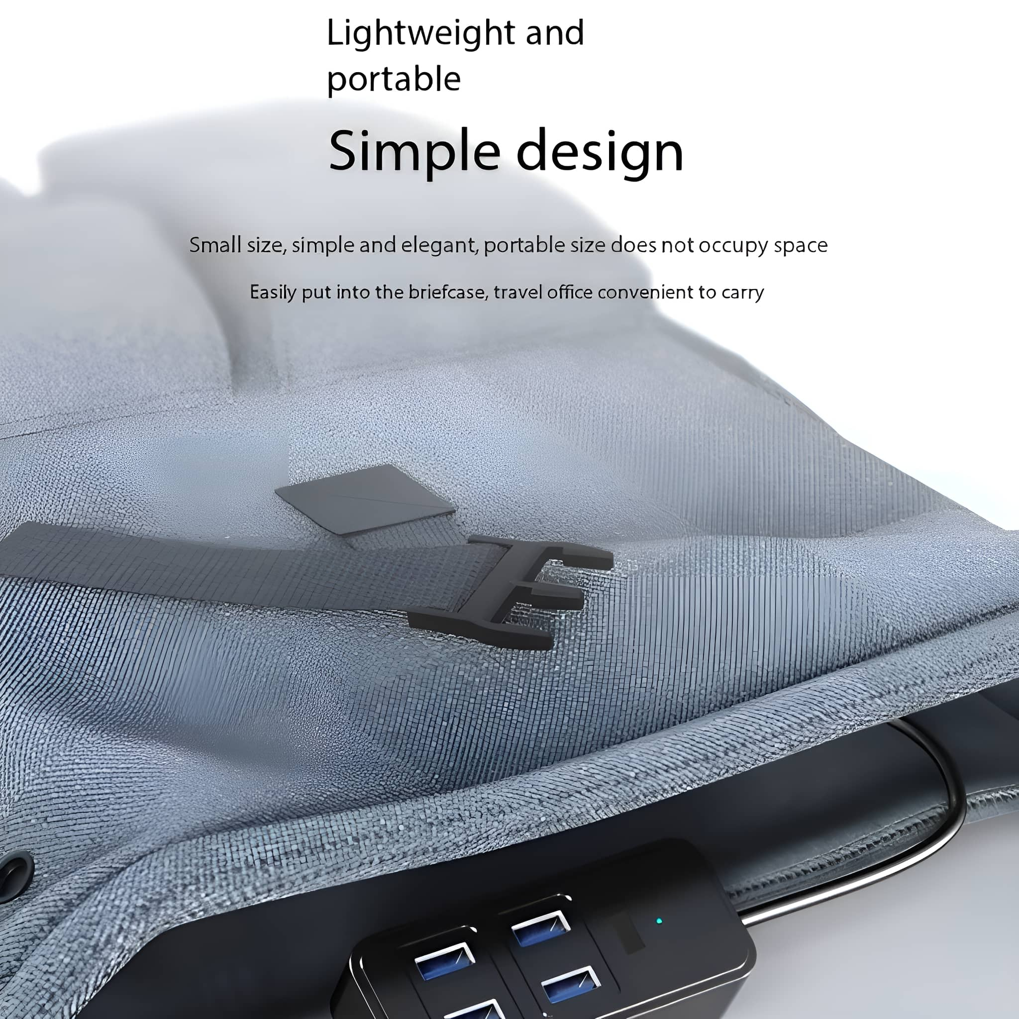 Ein schwarzer USB-Hub mit mehreren USB-Anschlüssen. Er befindet sich auf einem hellgrauen Hintergrund, in der Nähe einer Tasche.