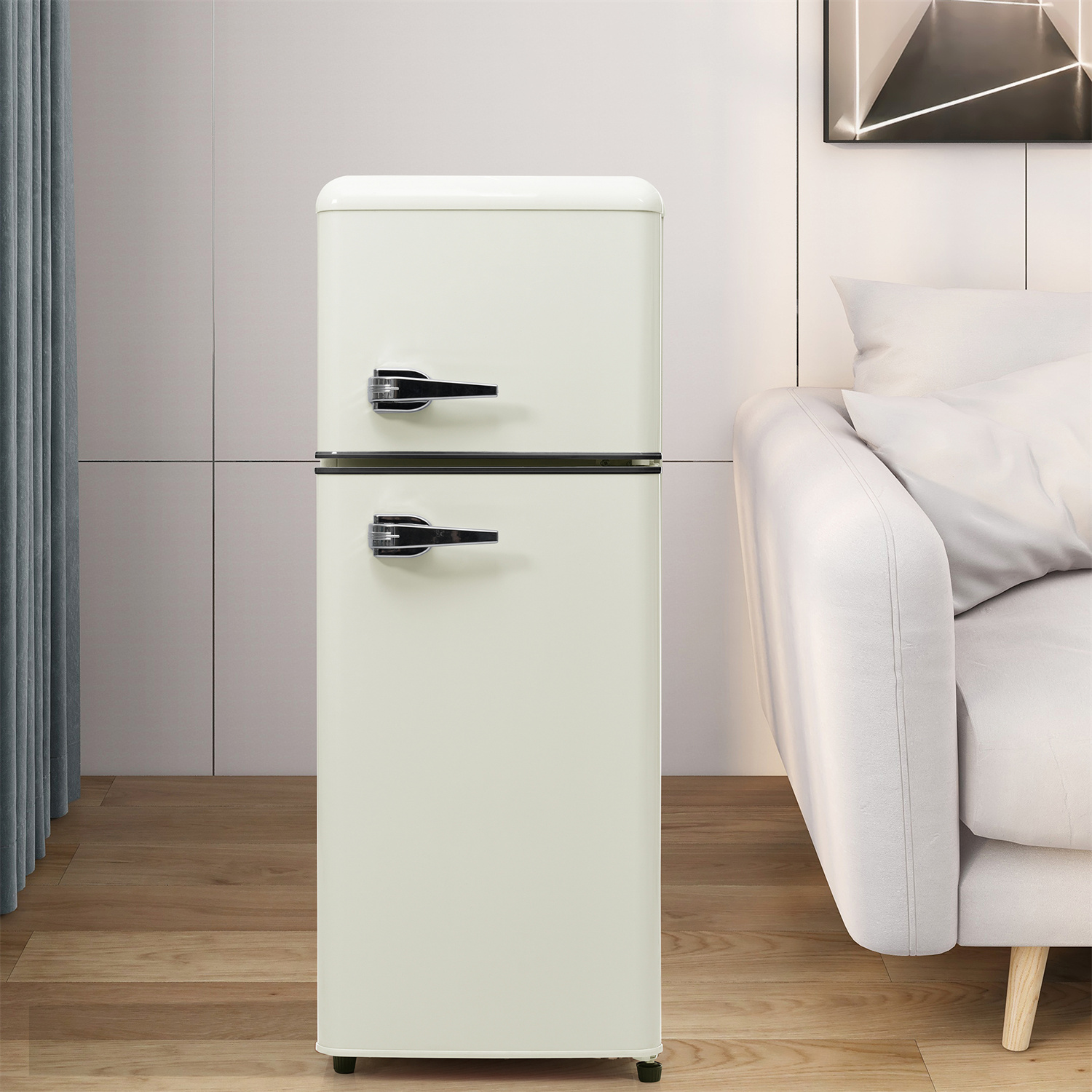 Cremefarbener Retro-Kühlschrank mit schwarzem Griff, in der Nähe eines Sofas.