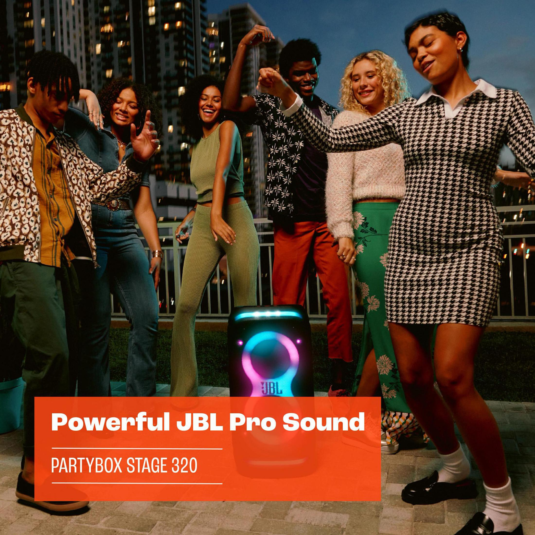 Eine Gruppe von Leuten tanzt in der Nähe eines JBL PartyBox-Lautsprechers mit Licht.
