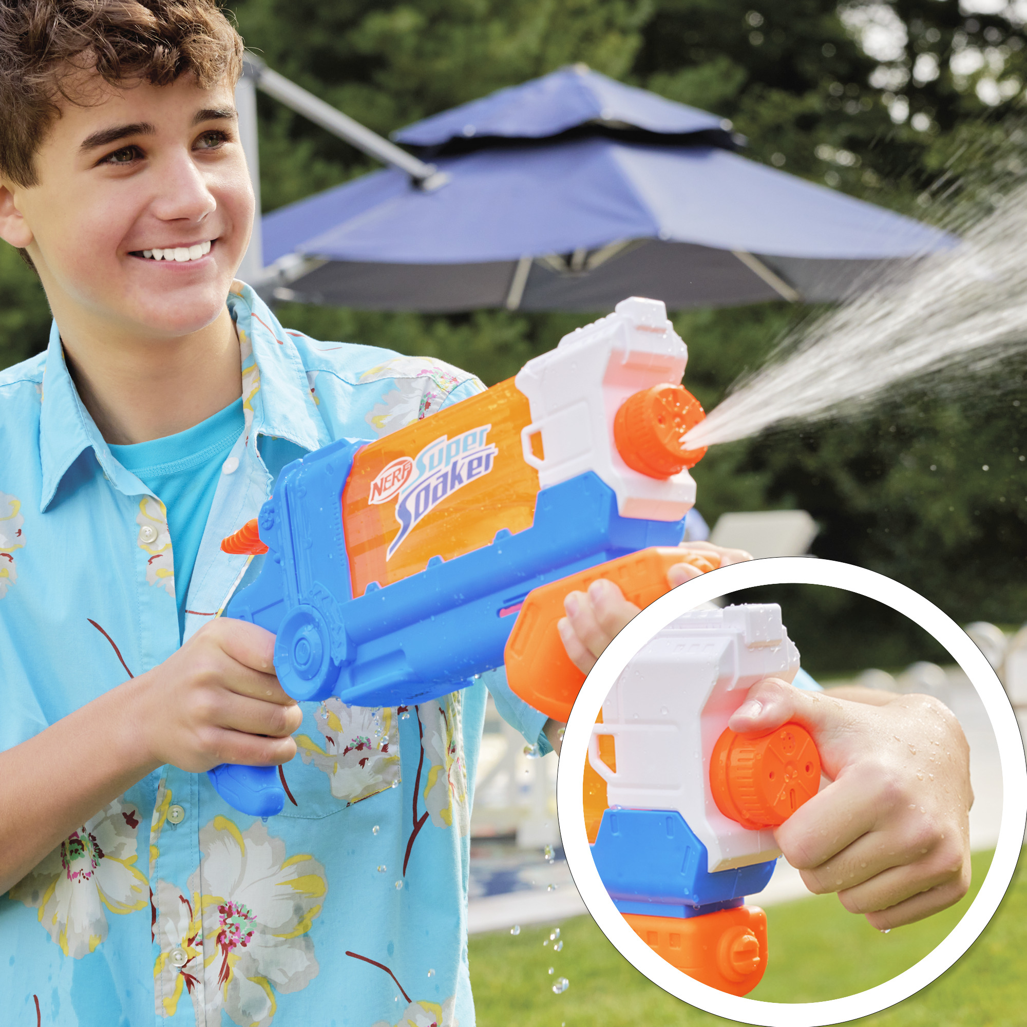 Un niño sostiene una pistola de agua azul y naranja, rociando agua con fondo borroso.